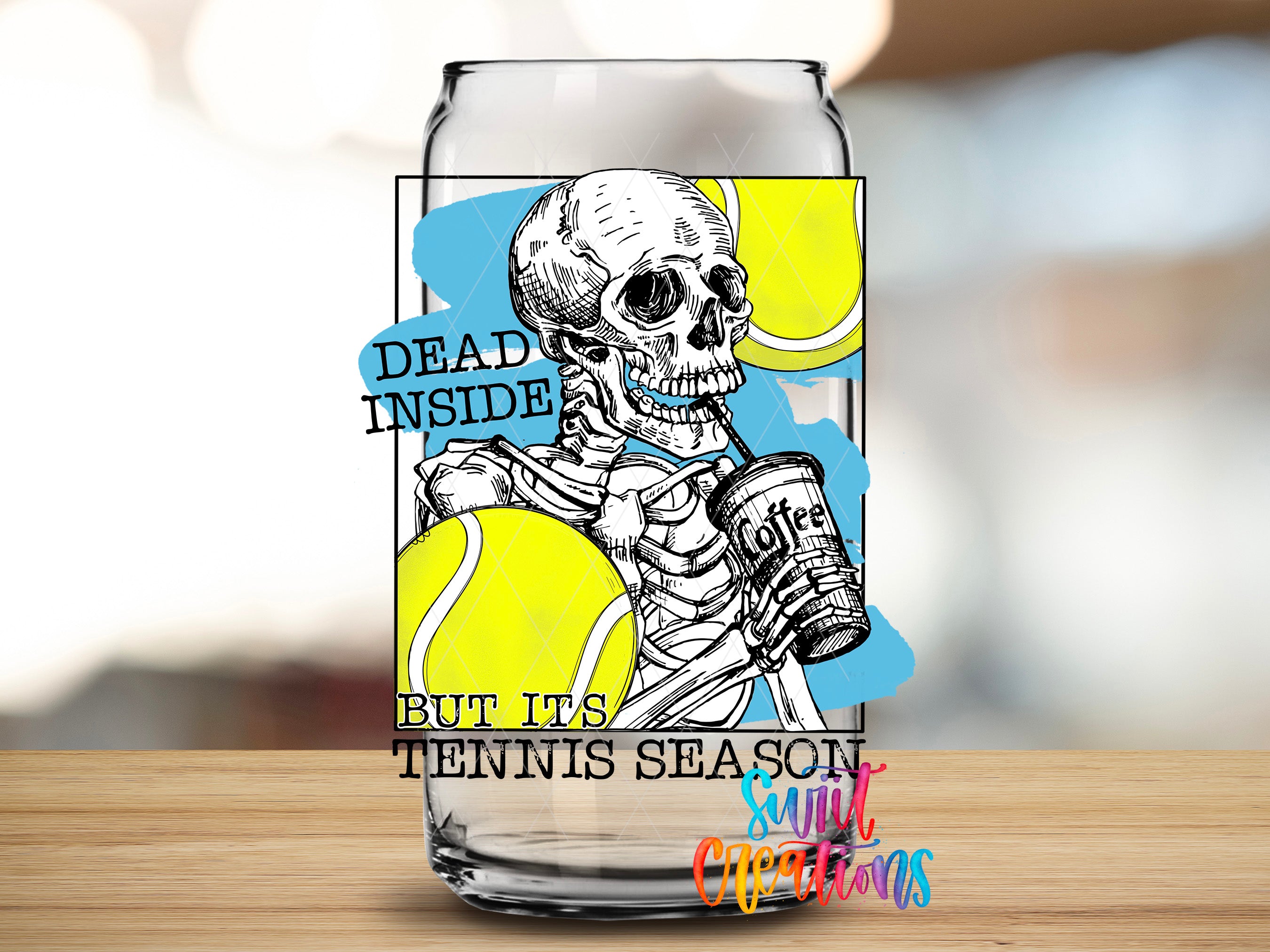 A glass can with a design featuring a skeleton holding a tennis racket and a yellow tennis ball, along with the text "Dead inside but its tennis season" and "Suitcase decorations".