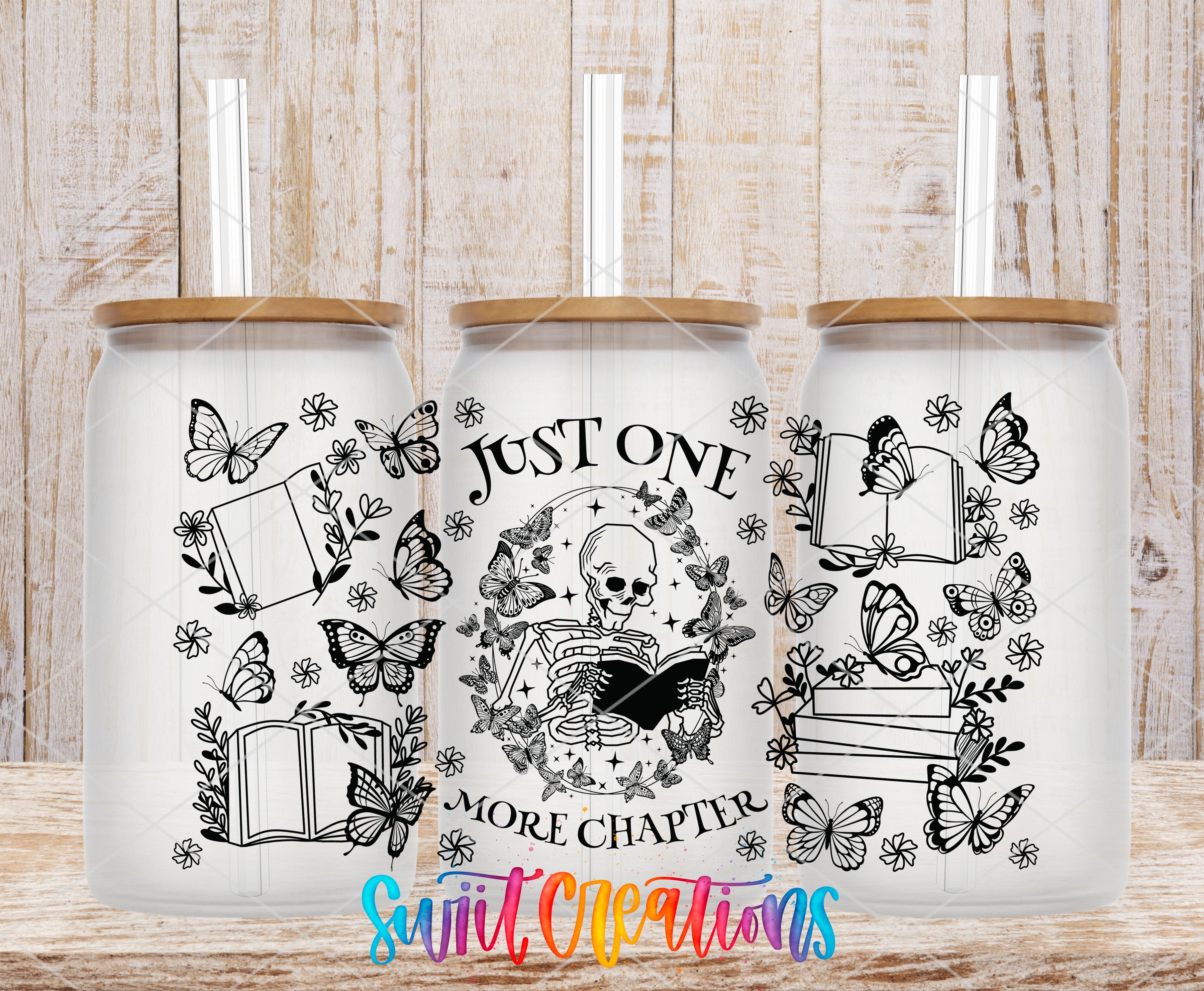 A trio of white tumblers with black illustrations and text on them, set against a wooden background.