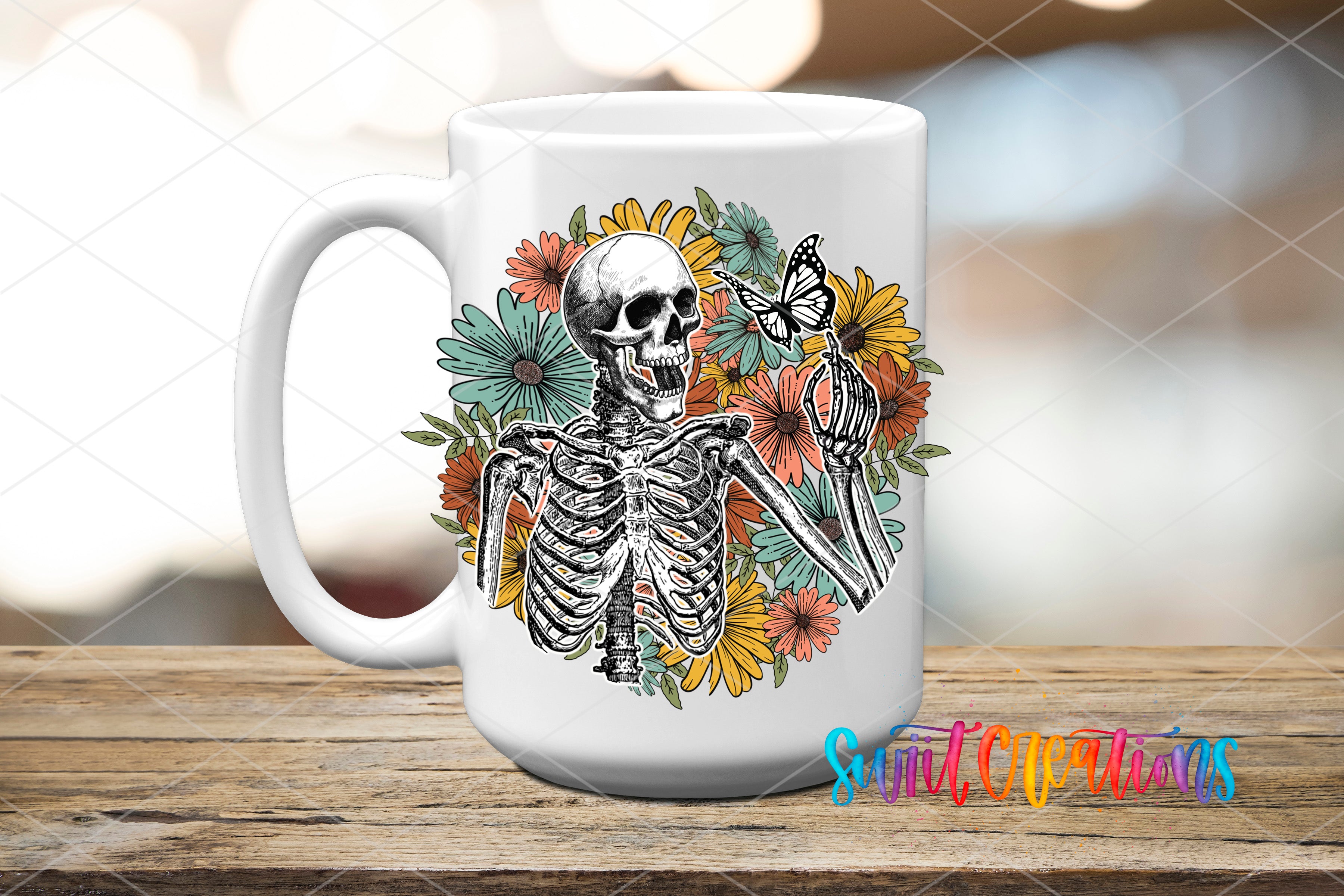 A white ceramic mug with a black and white illustration of a skeleton surrounded by colorful flowers and butterflies.