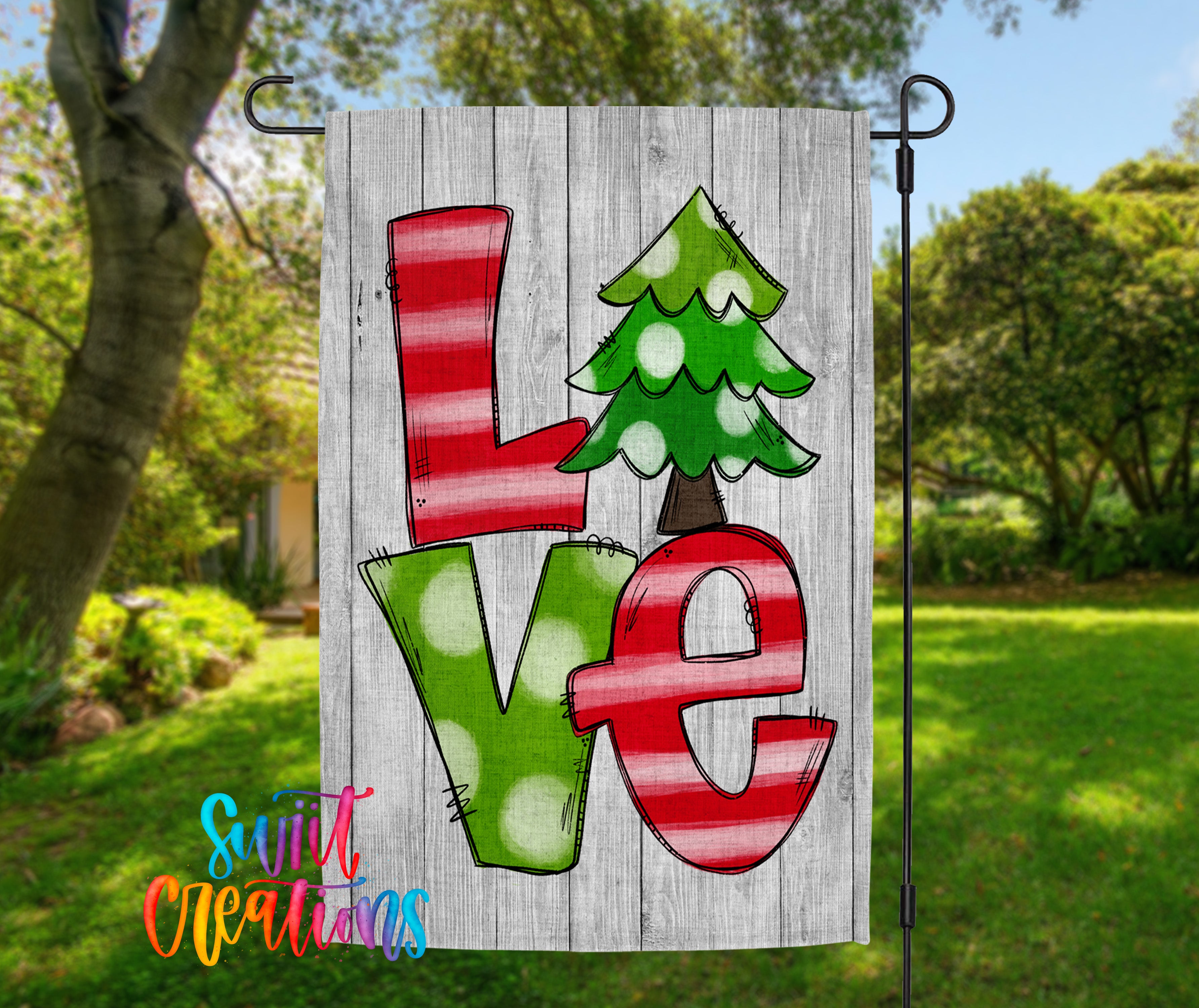 A colorful garden flag with the word "Love" written on it, featuring a Christmas tree design.
