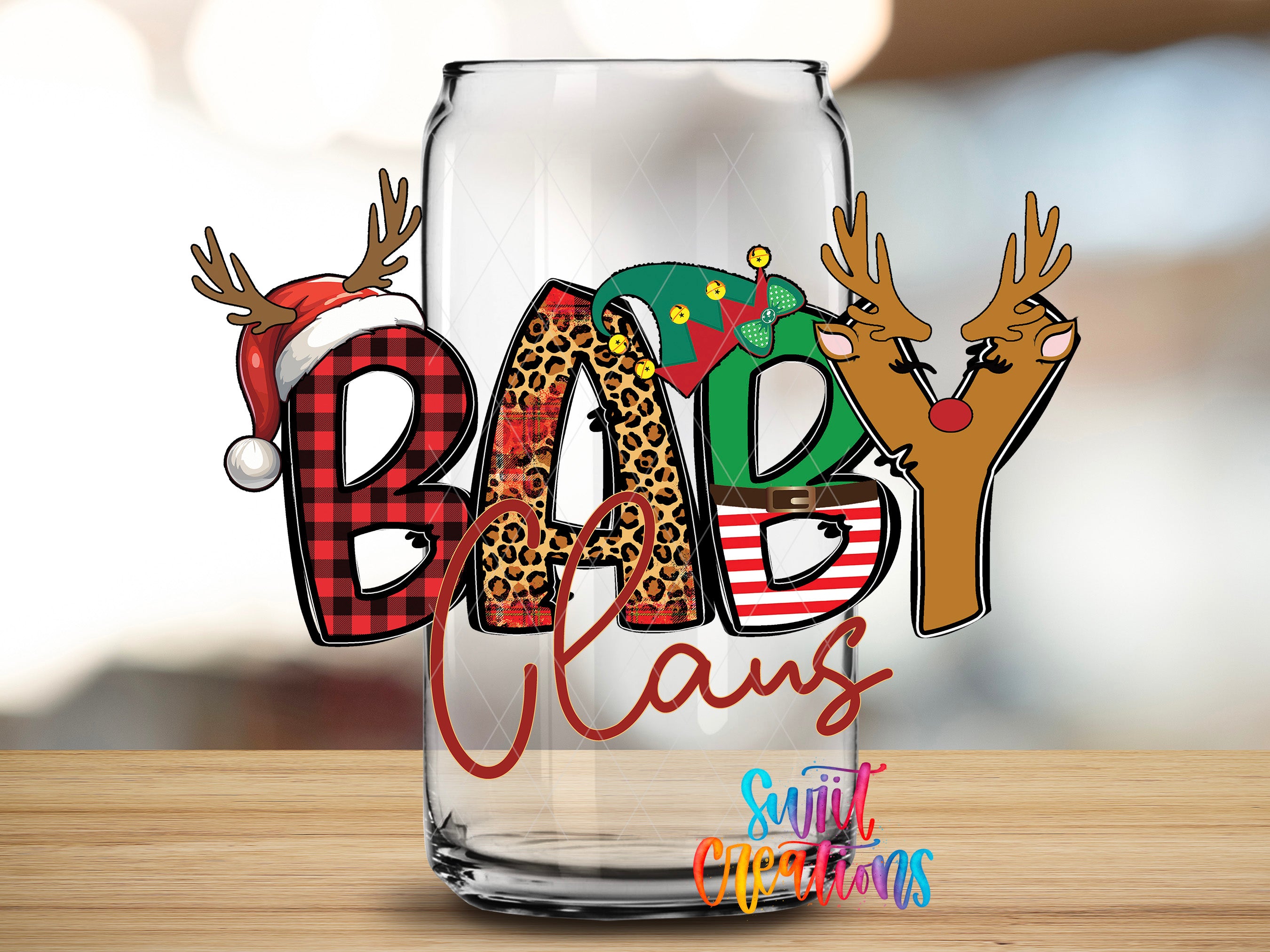 A glass with the word "BABY CLAN" written on it, along with a Santa hat and reindeer decorations.