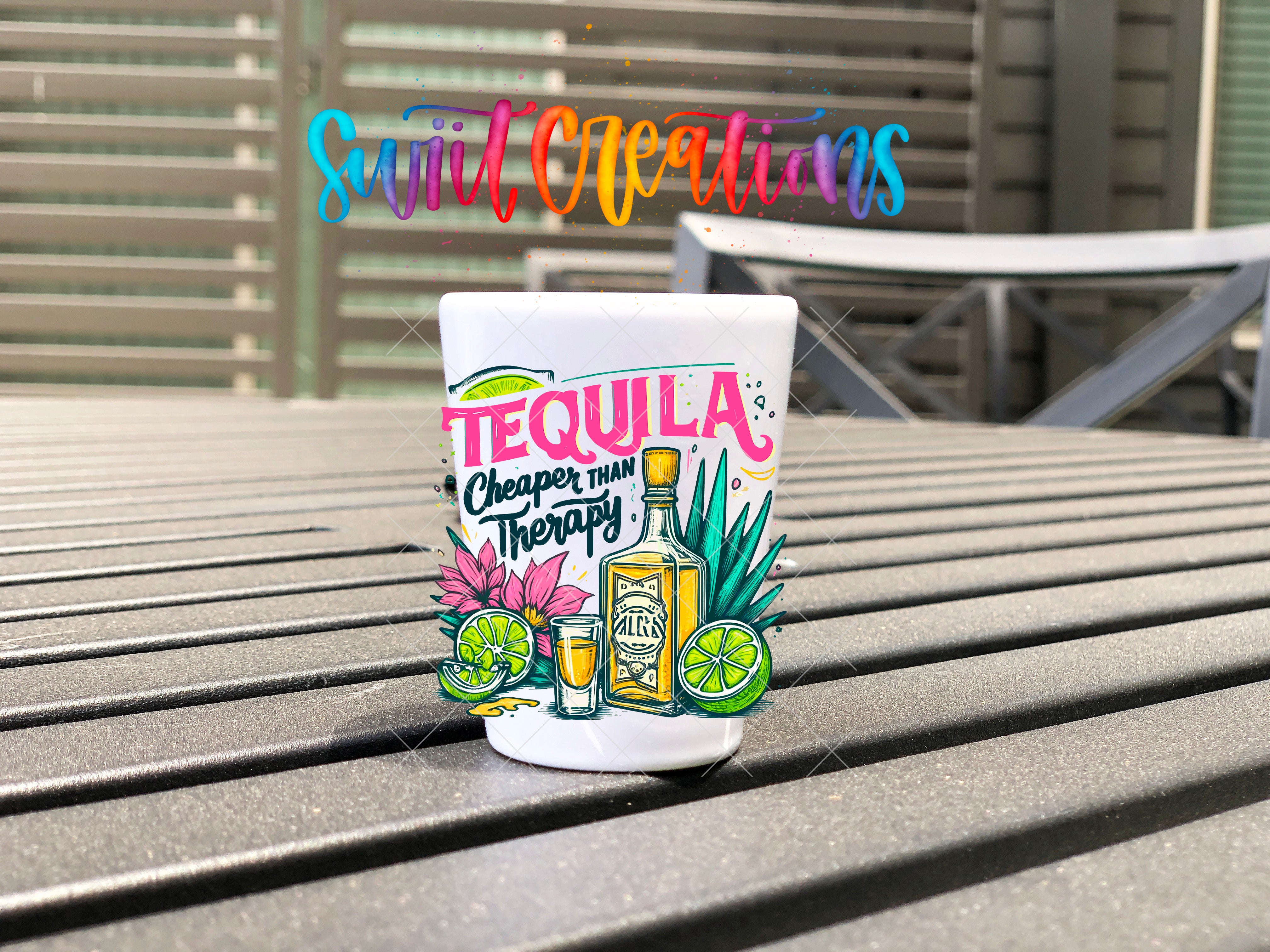 A colorful tequila-themed mug or cup with the text "Tequila Cheaper than Therapy" printed on it, placed on a wooden surface.