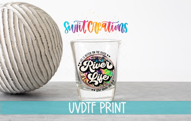 a shot glass next to a ball of yarn