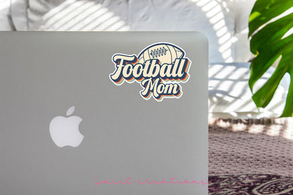 Football Mom sticker on the lid of a silver laptop