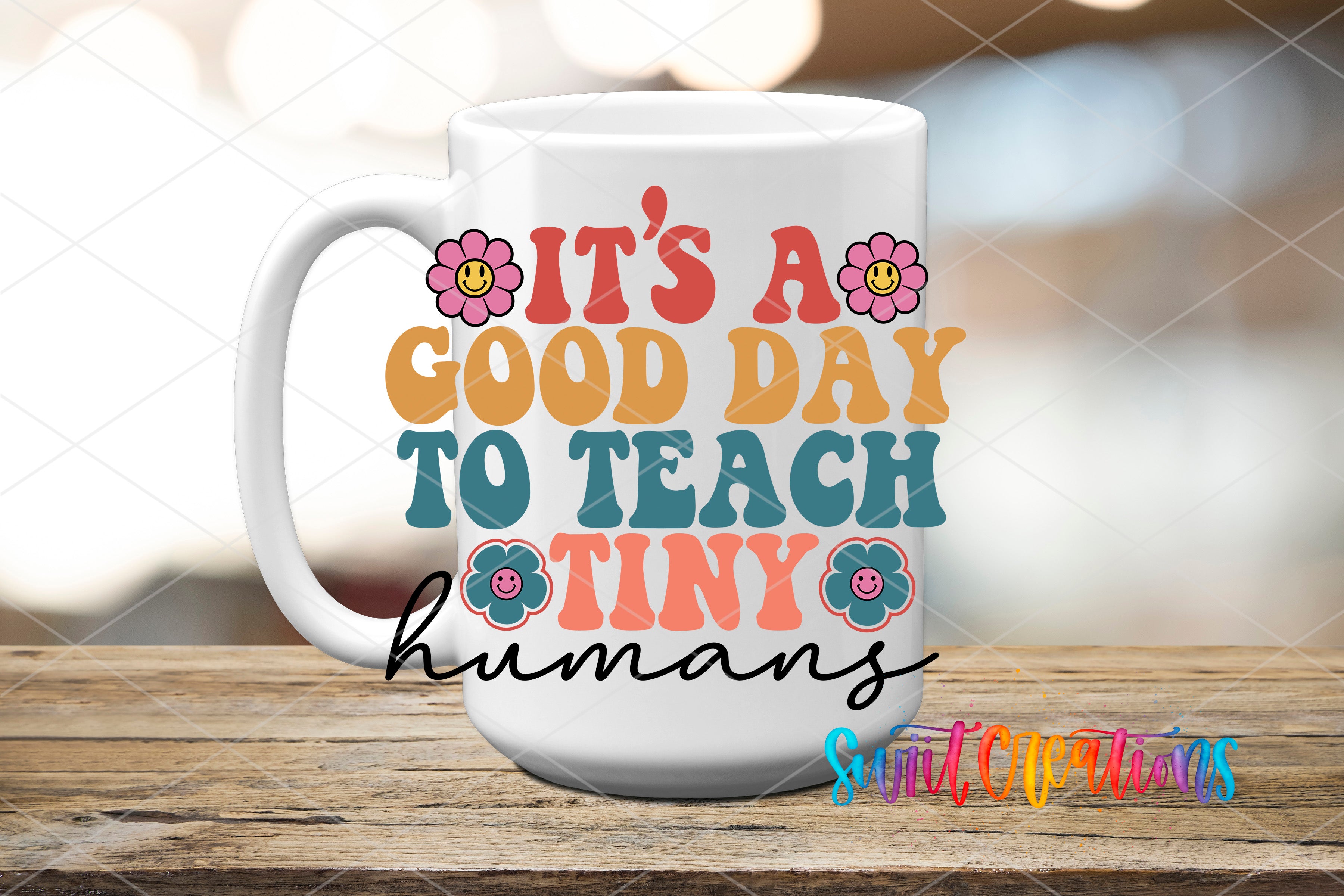 A white mug with colorful text and flower graphics on it, placed on a wooden surface.