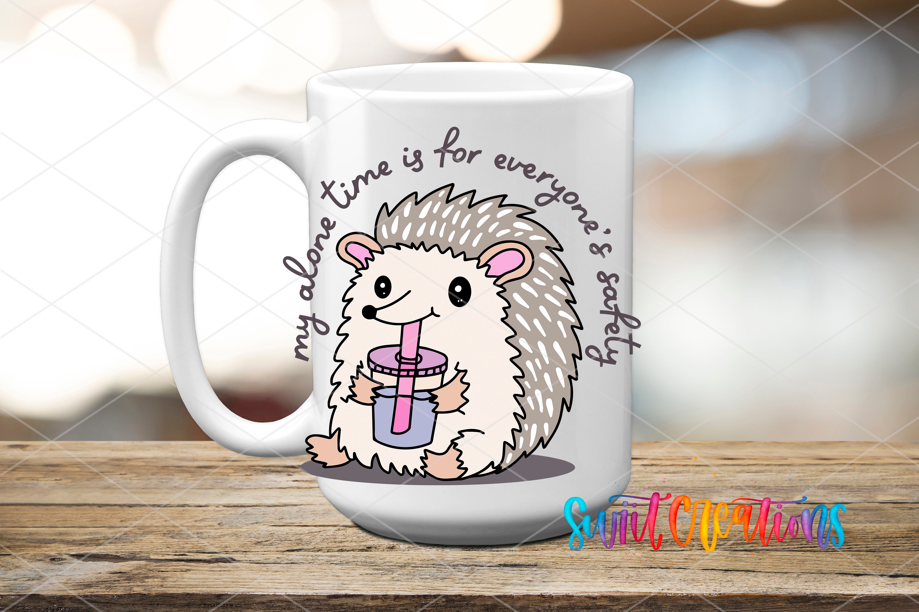 A white ceramic mug with a cartoon hedgehog holding a drink, accompanied by the text "My alone time is for everyone's safety" and "Suitcase Creations" written on it.