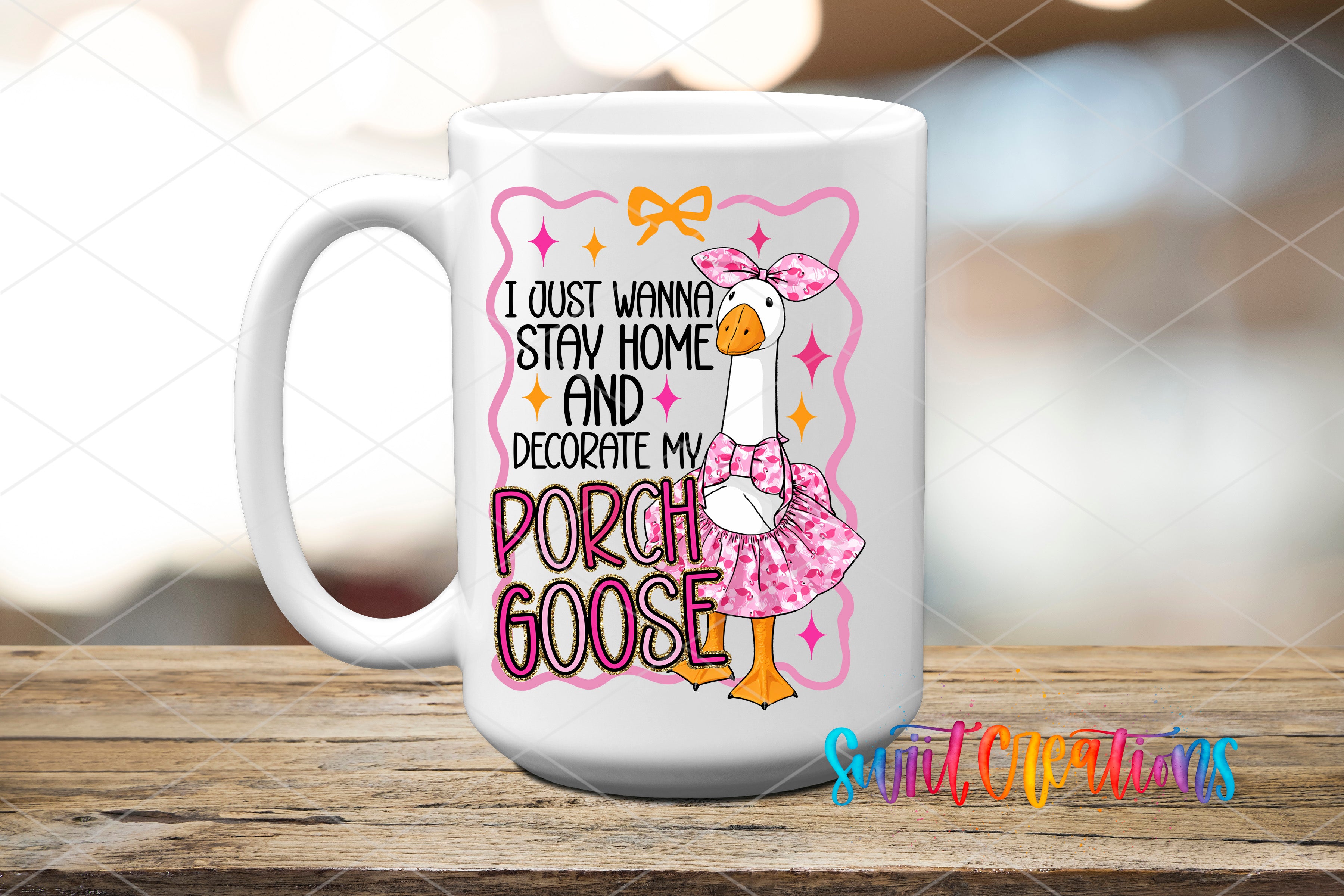 A white ceramic mug with a cartoon image of a goose wearing a pink dress and bow, along with text that says "I just wanna stay home and decorate my porch goose".