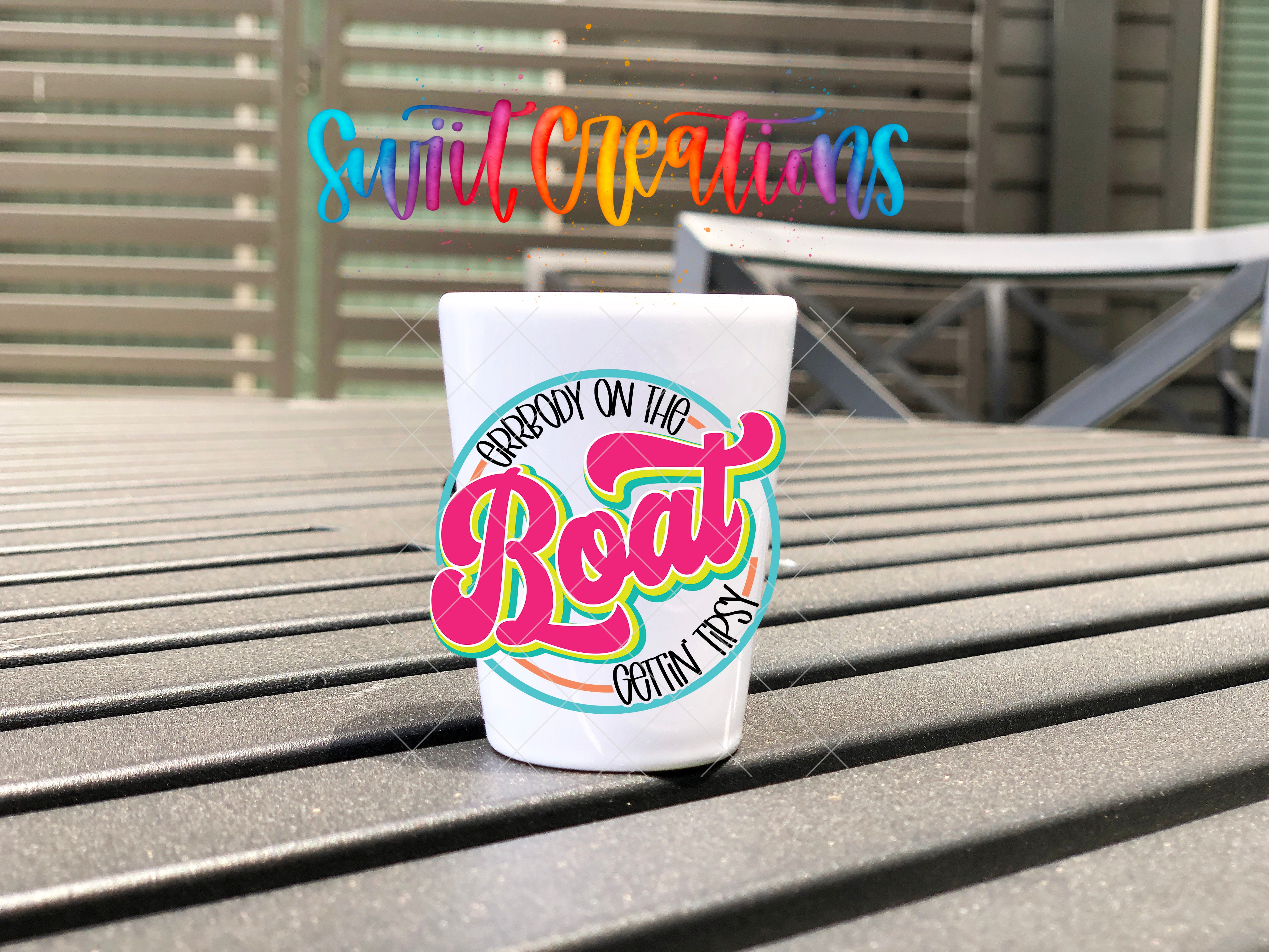A white cup with a colorful graphic design on it, placed on a wooden surface.