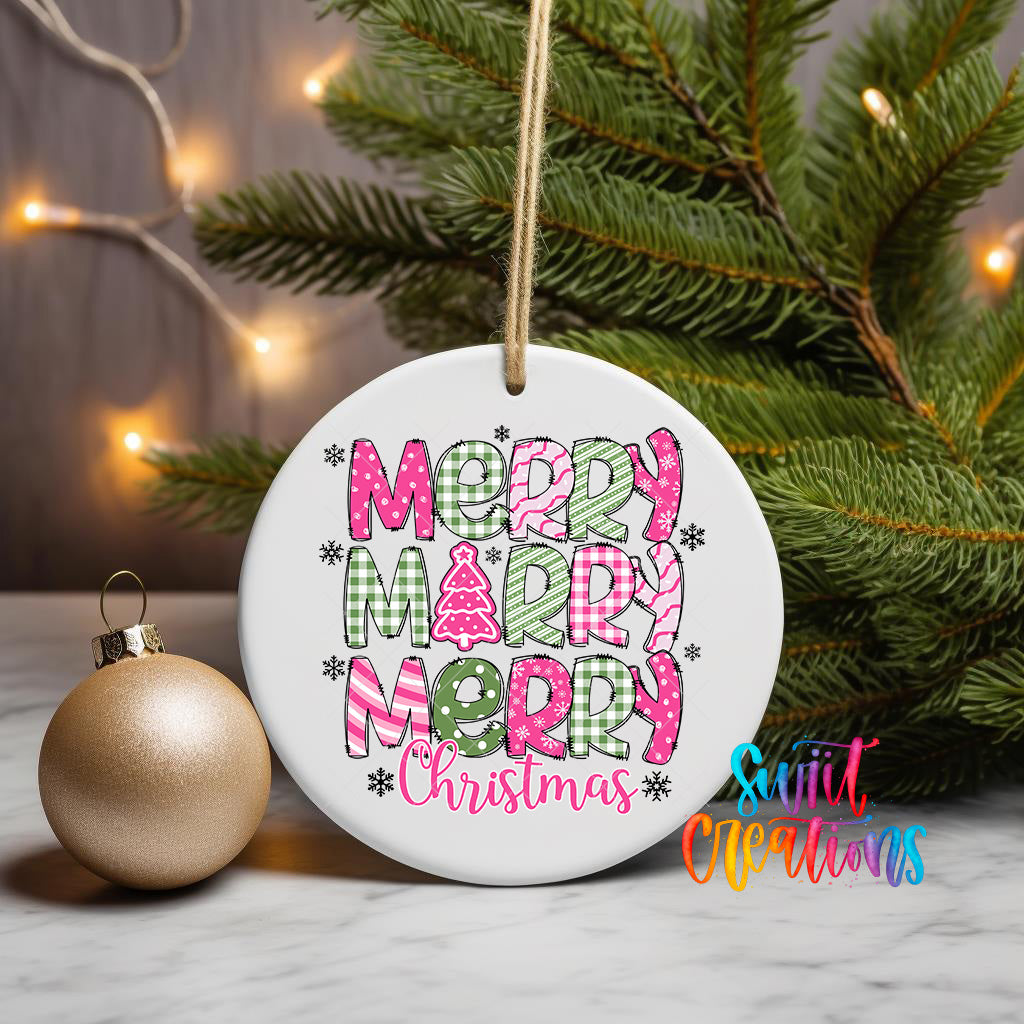 A white ceramic ornament with the text "MERRY MERRY CHRISTMAS" in pink and green colors, hanging on a Christmas tree branch.