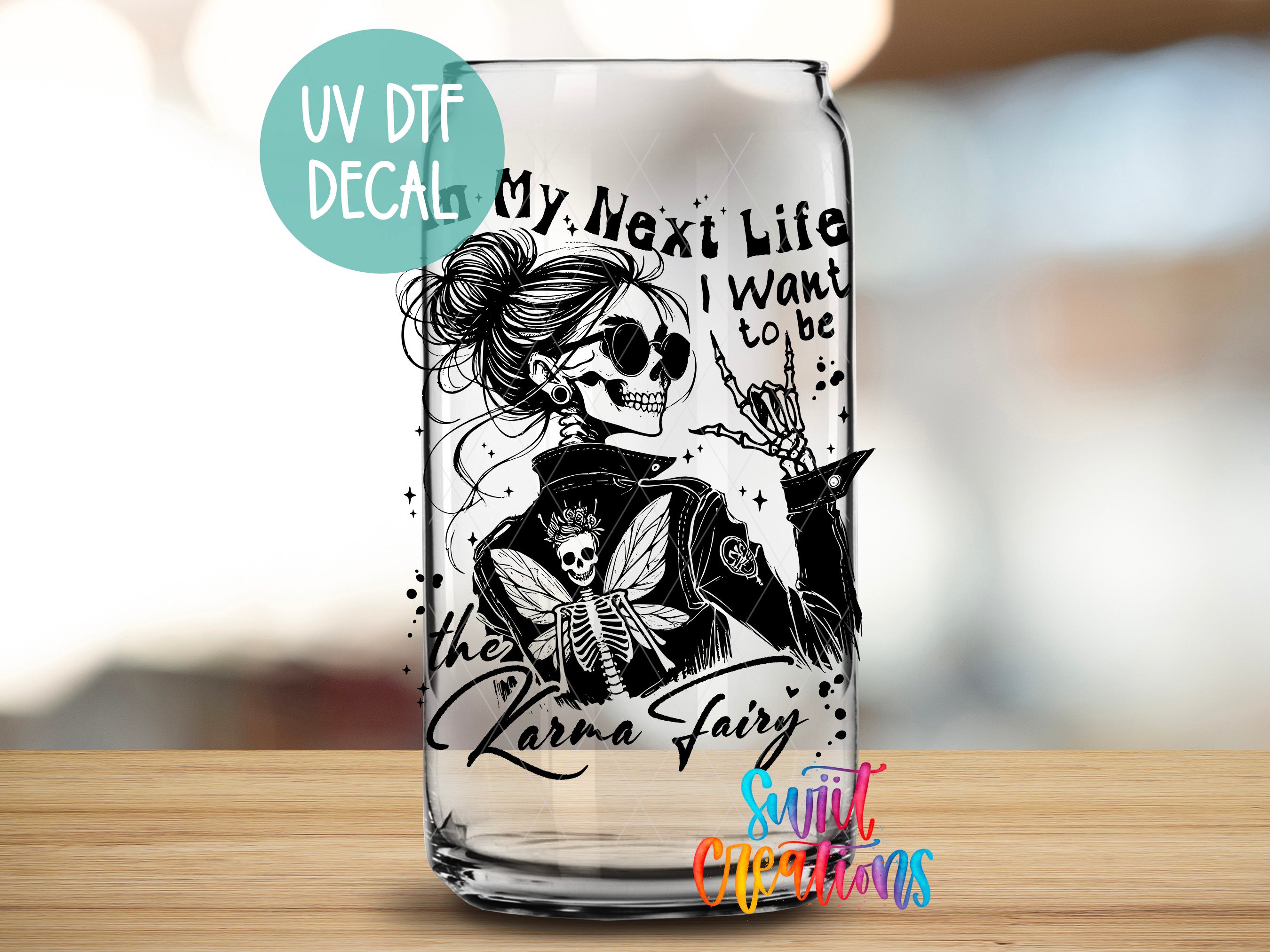 A glass can with a black and white illustration of a skeleton wearing sunglasses and a crown, along with the text "My Next Life I Want to be the Karma Fairy" printed on it.