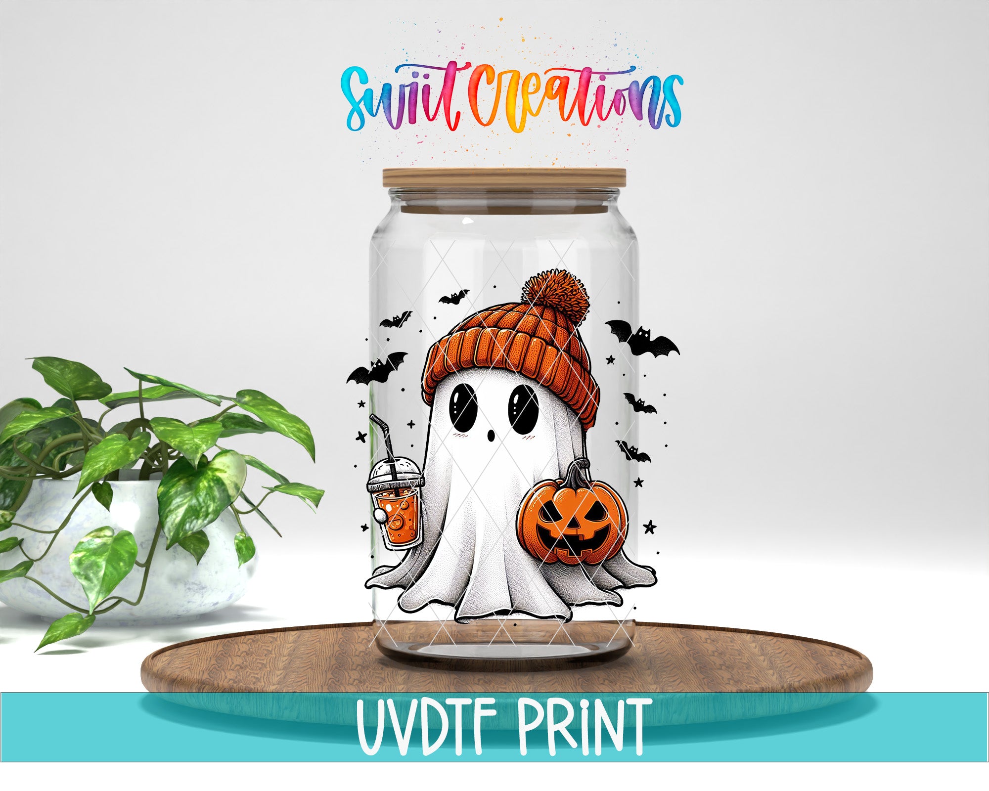 A glass jar with a Halloween-themed ghost wearing a hat and holding a pumpkin, surrounded by bats and a pumpkin, placed on a wooden surface.