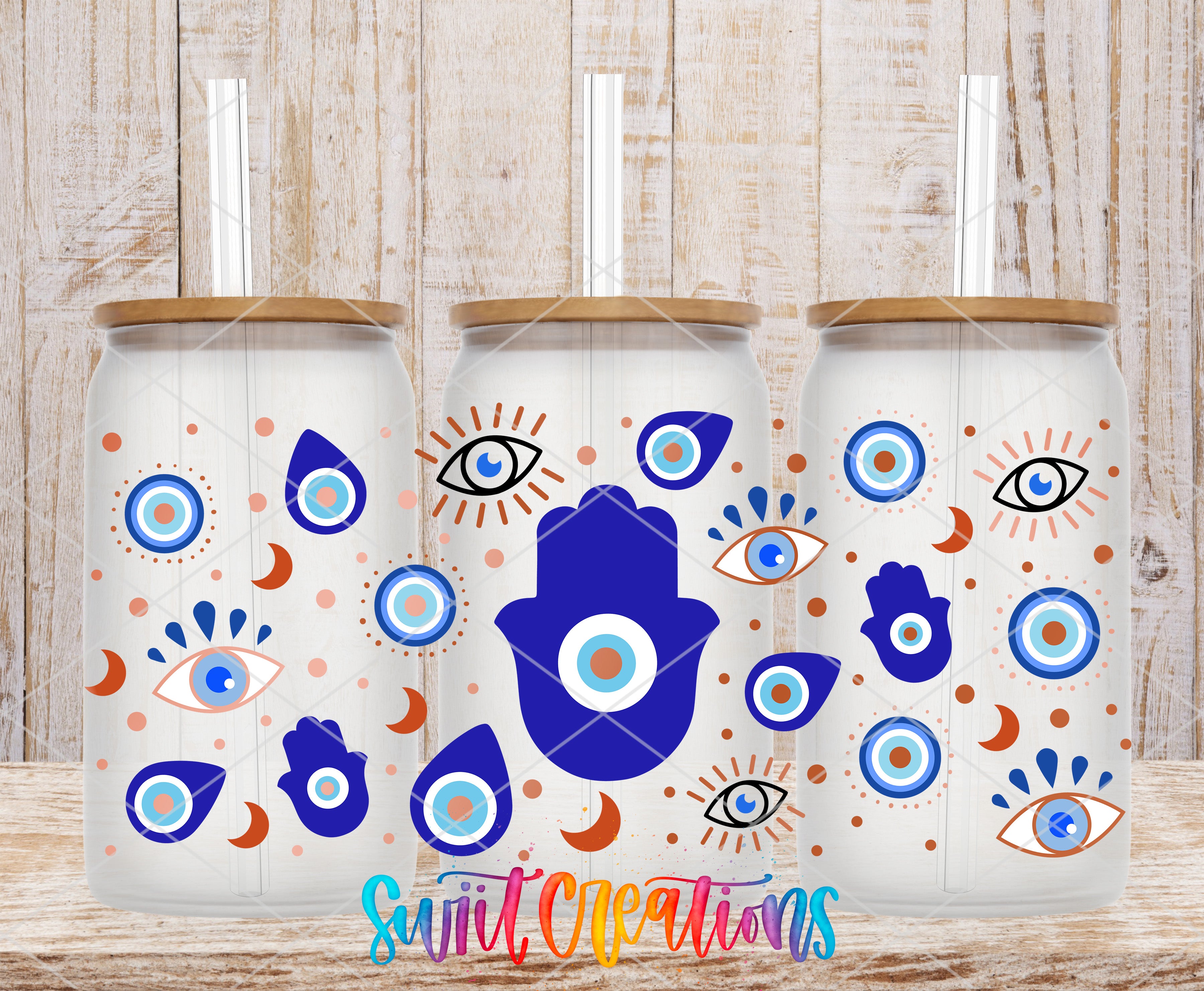 three glass tumblers with a unique design, including blue and orange eyes, hands, and other whimsical patterns.
