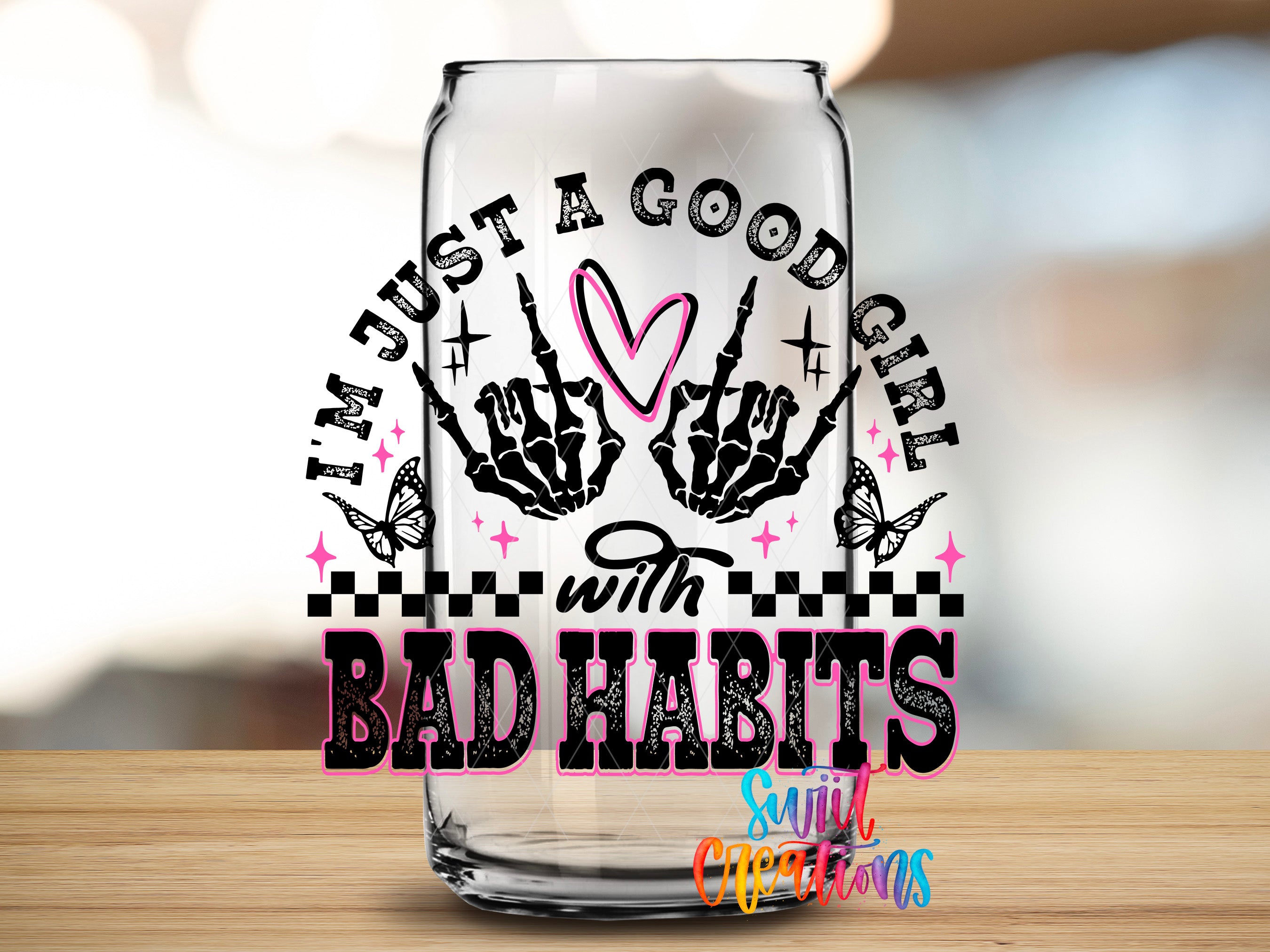 A glass can with a printed design on it, featuring the text "I'm just a good girl with bad habits" and various decorative elements such as butterflies and stars.