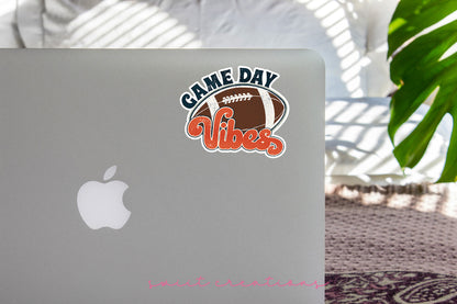 Football Game Day Vibes sticker on the lid of a silver laptop