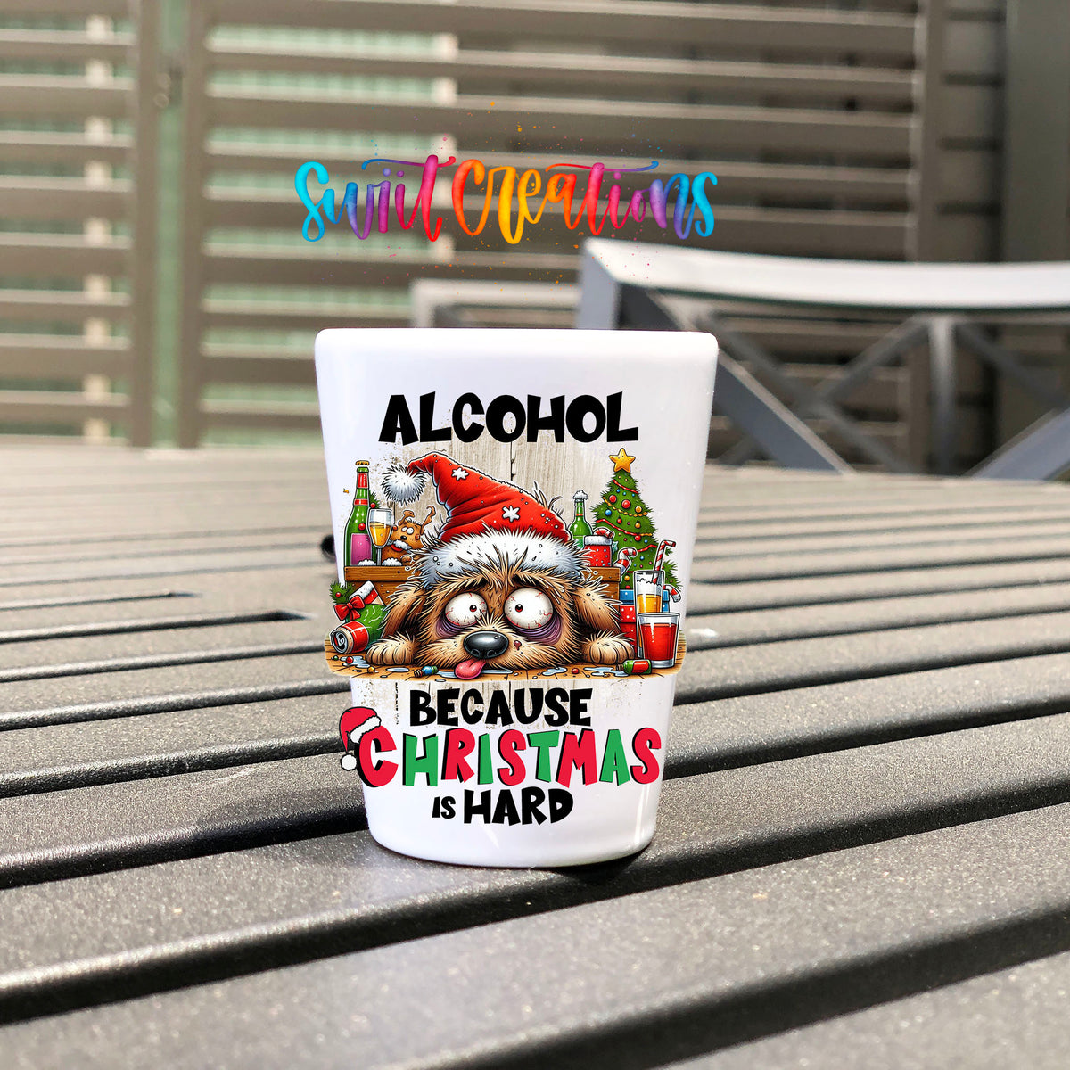 Alcohol Because Christmas is Hard UV DTF transfer on a white shot glass on an outdoor patio table