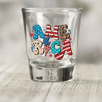 America shot glass UV DTF transfer with star, stripe, and leopard print lettering on a clear shot glass