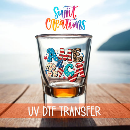 America shot glass UV DTF transfer on a filled shot glass on a dock by the water