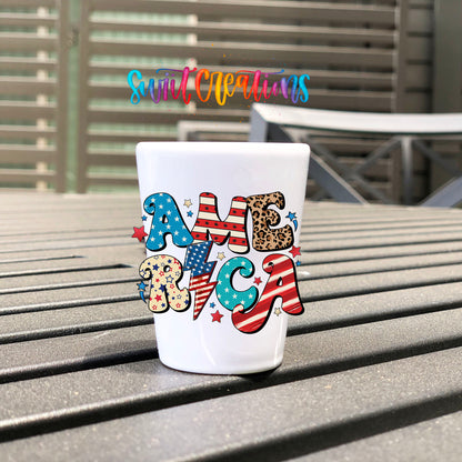 America UV DTF transfer on a white shot glass on an outdoor patio table
