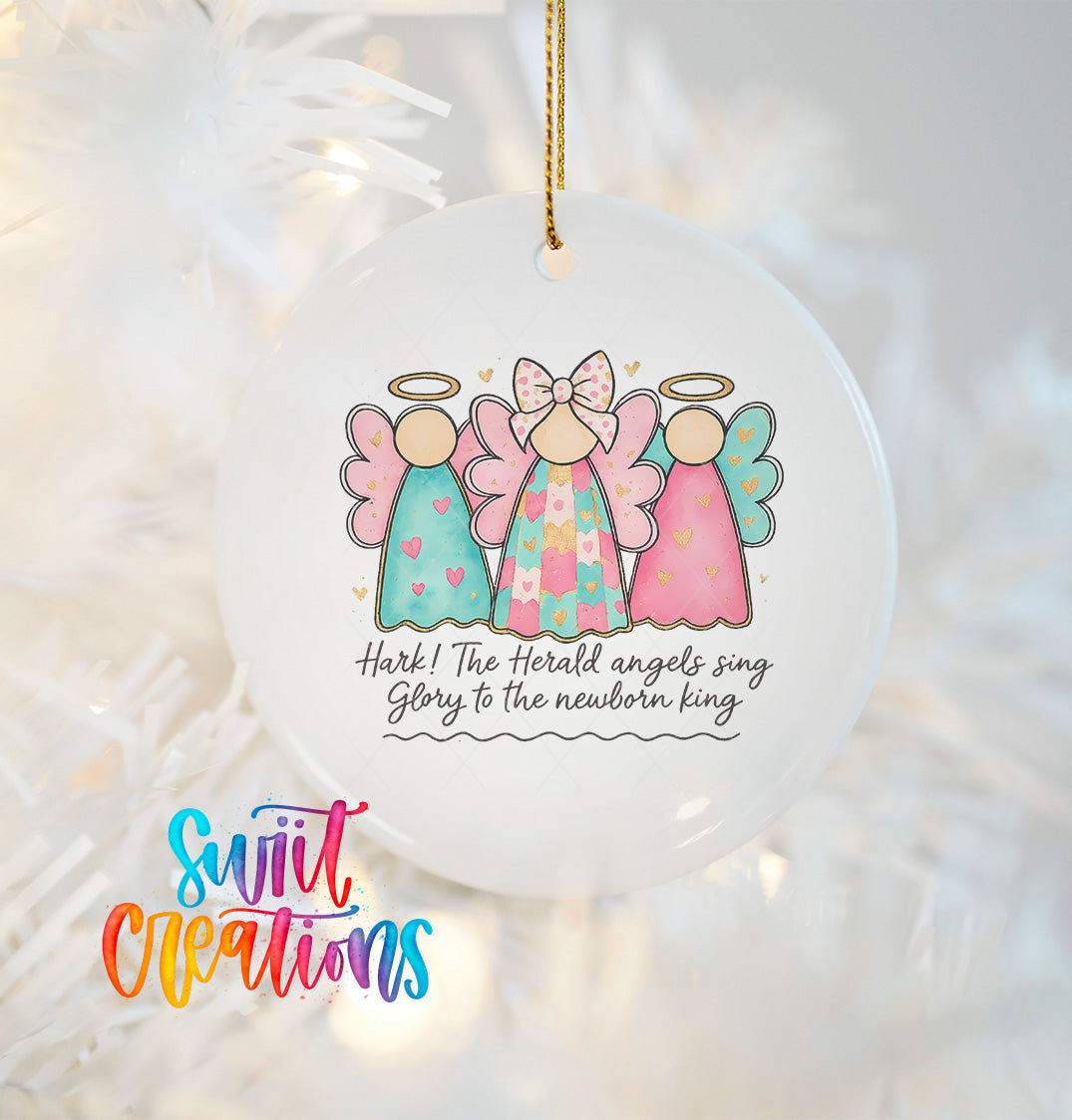 A white ornament with three colorful angel figures and a text that reads "Hark! The herald angels sing glory to the newborn king"