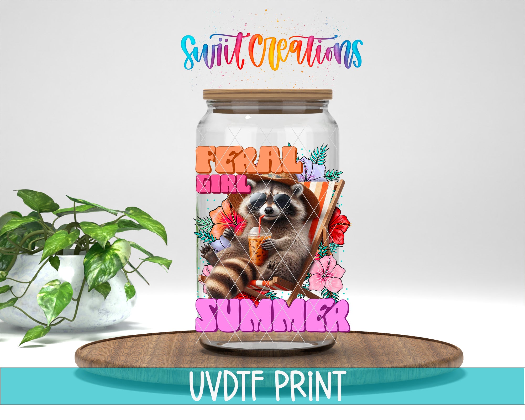A glass jar with a raccoon design and the text "Feral Girl Summer" printed on it, placed on a wooden surface next to a potted plant.