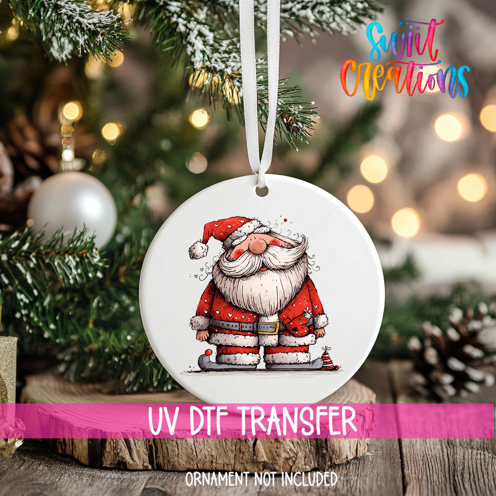 A white ornament with a Santa Claus illustration is hanging on a Christmas tree, with a blurred background of pine branches and twinkling lights.