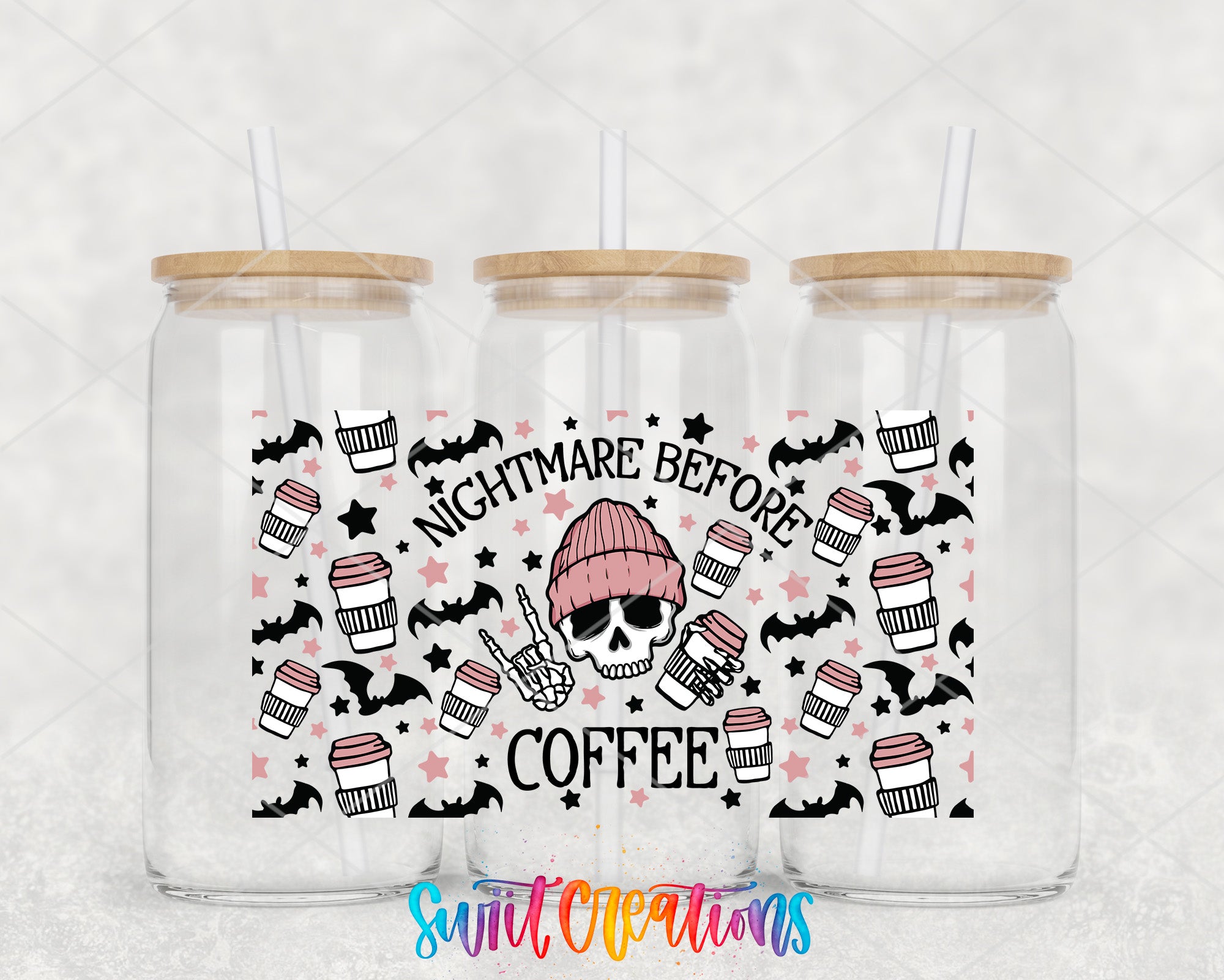 three clear glass tumblers with wooden lids, each with a straw. The tumblers are decorated with a black and white skull design and the text "NIGHTMARE BEFORE COFFEE" printed on them.