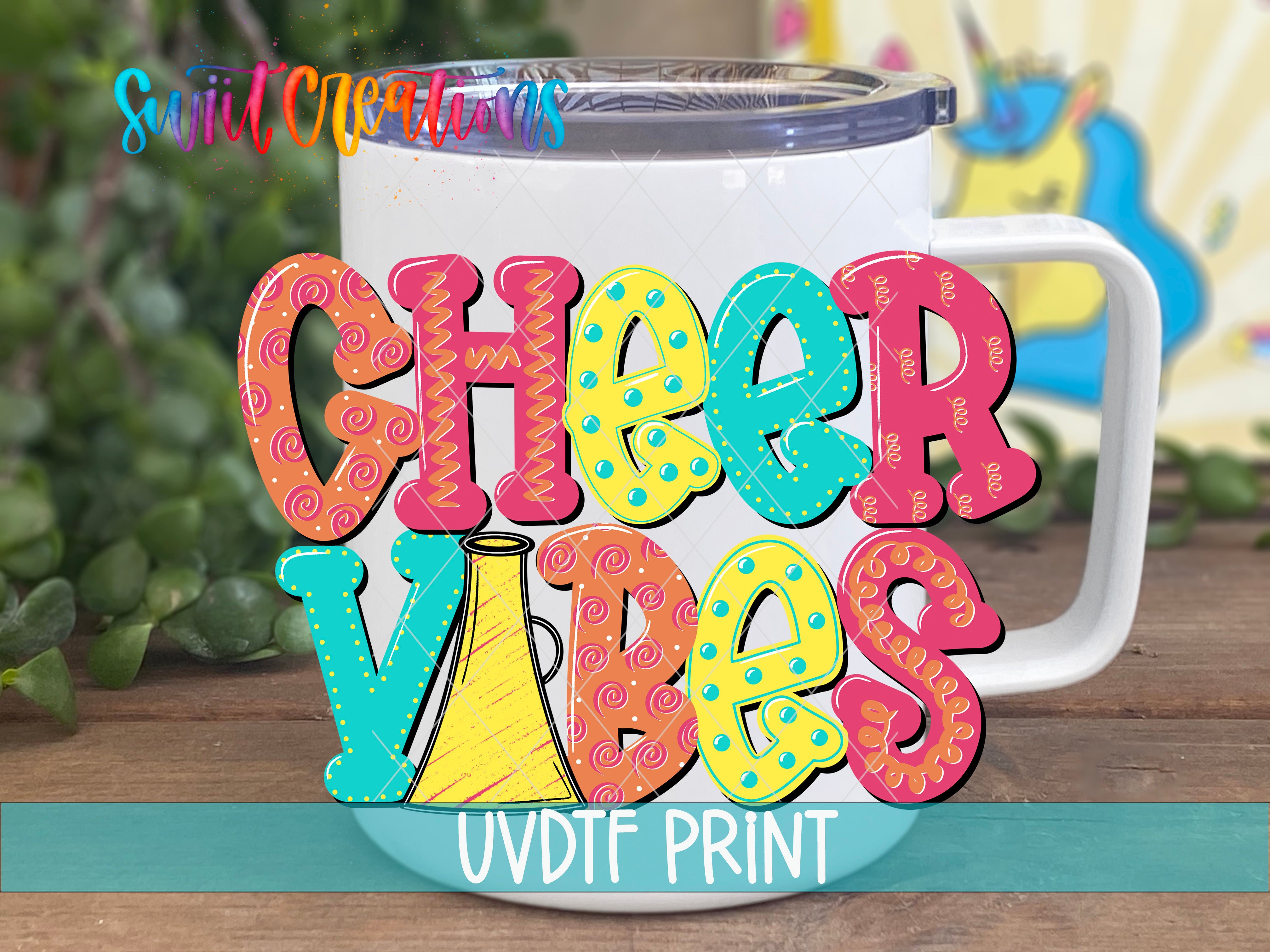 A colorful mug with the text "CHEER VIBES" printed on it, along with a unicorn and other whimsical elements.