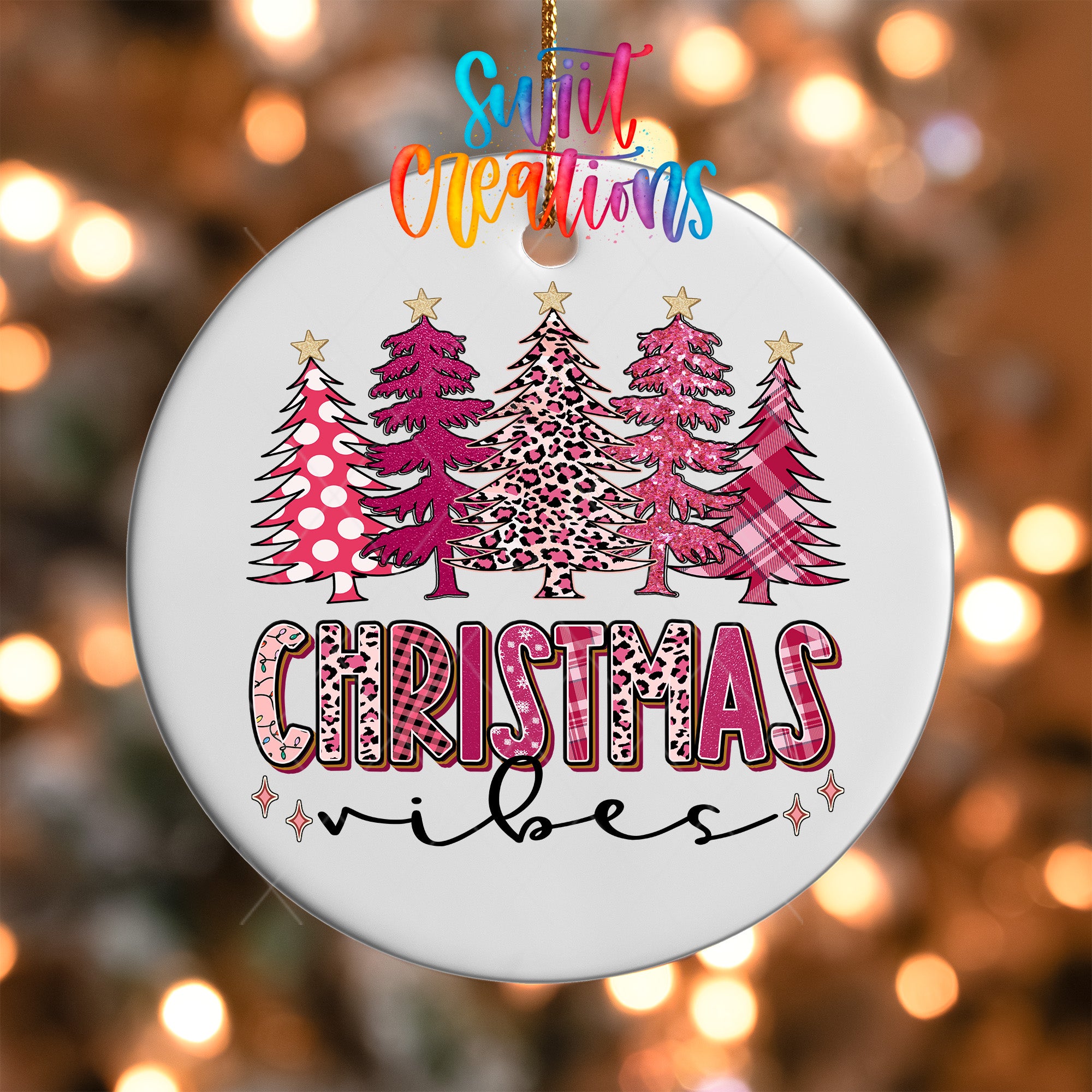 A white Christmas ornament with a design of pink and leopard print trees, along with the text "Christmas vibes" written in a colorful, stylized font.