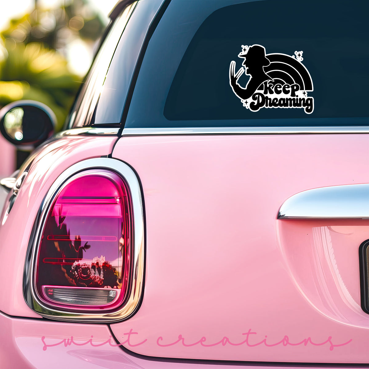 Keep Dreaming sticker on the back window of a pink car