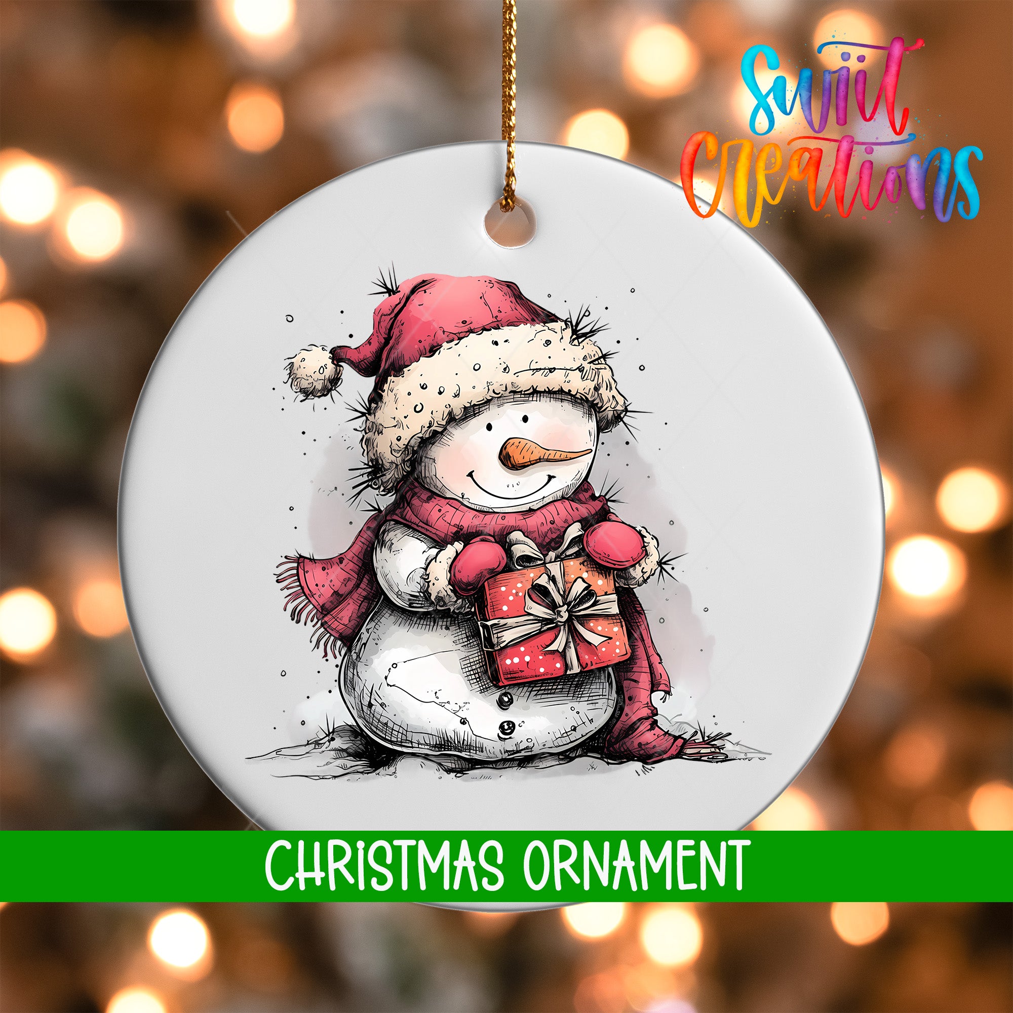 A white Christmas ornament featuring a snowman holding a gift box, with a blurred background of Christmas lights.