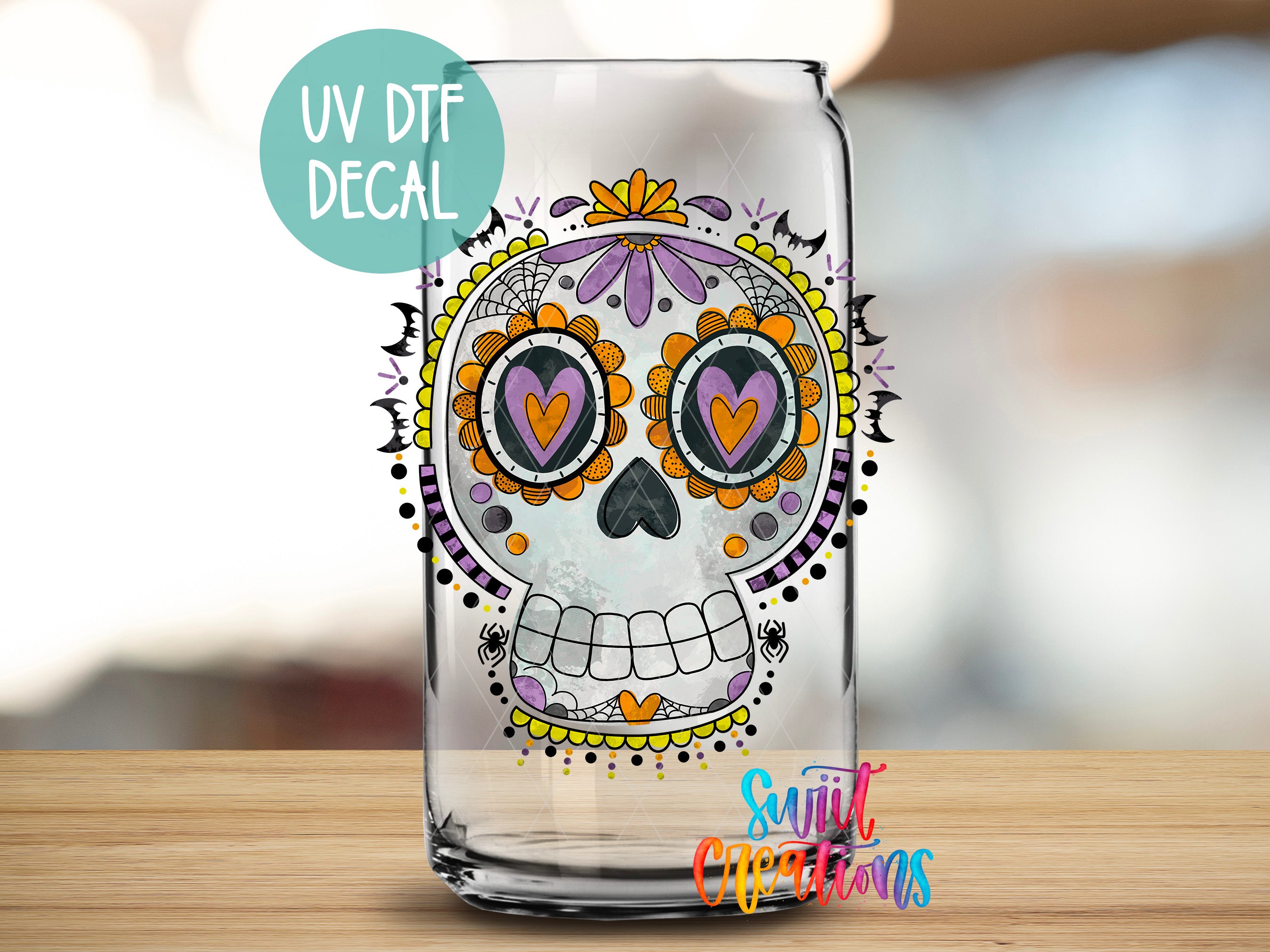 A glass can with a colorful, intricate skull design printed on it, featuring a skull with a flower pattern and decorative elements.