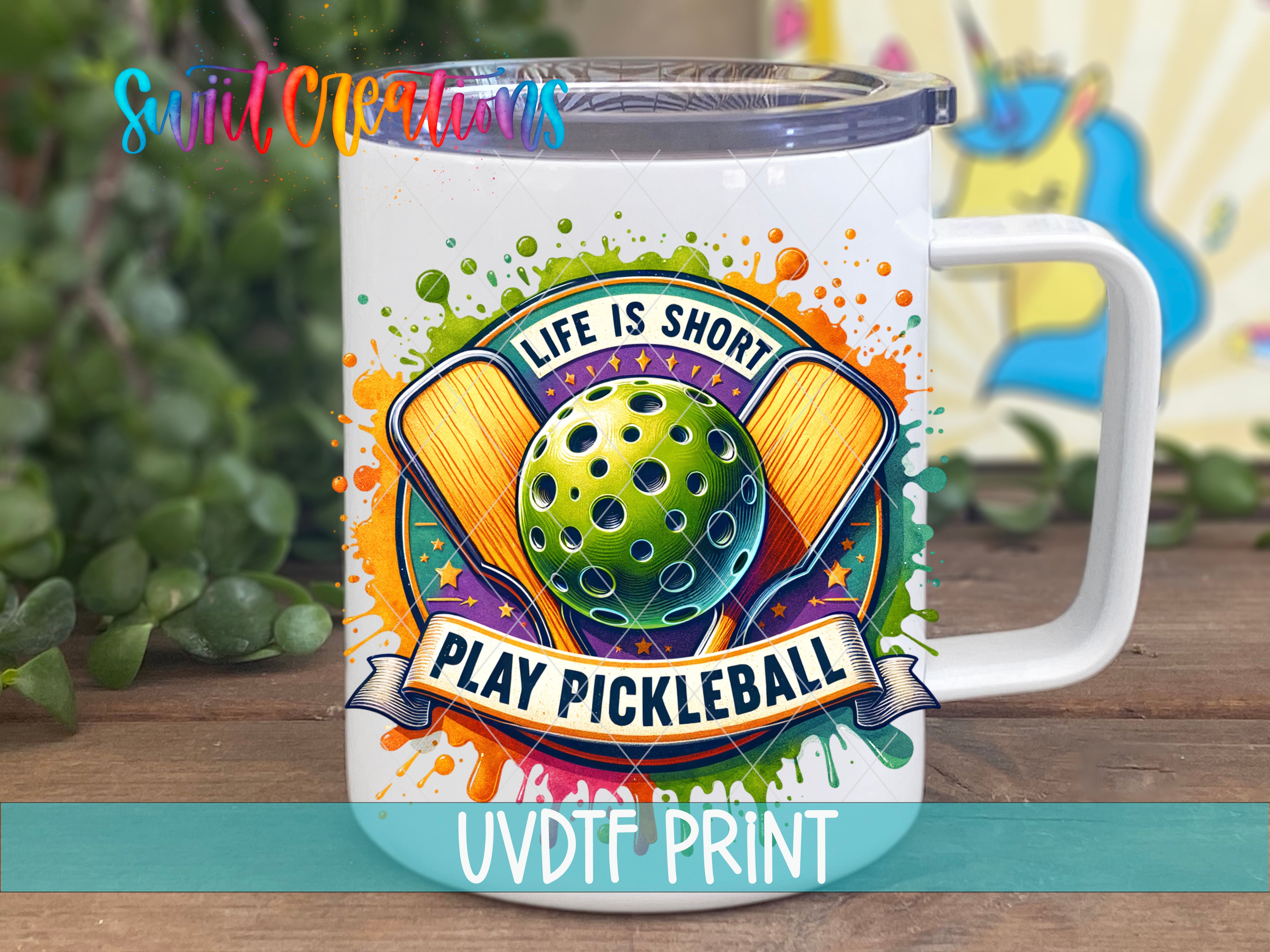 A white mug with a colorful design featuring a pickleball and the text "Life is short, play pickleball" printed on it.