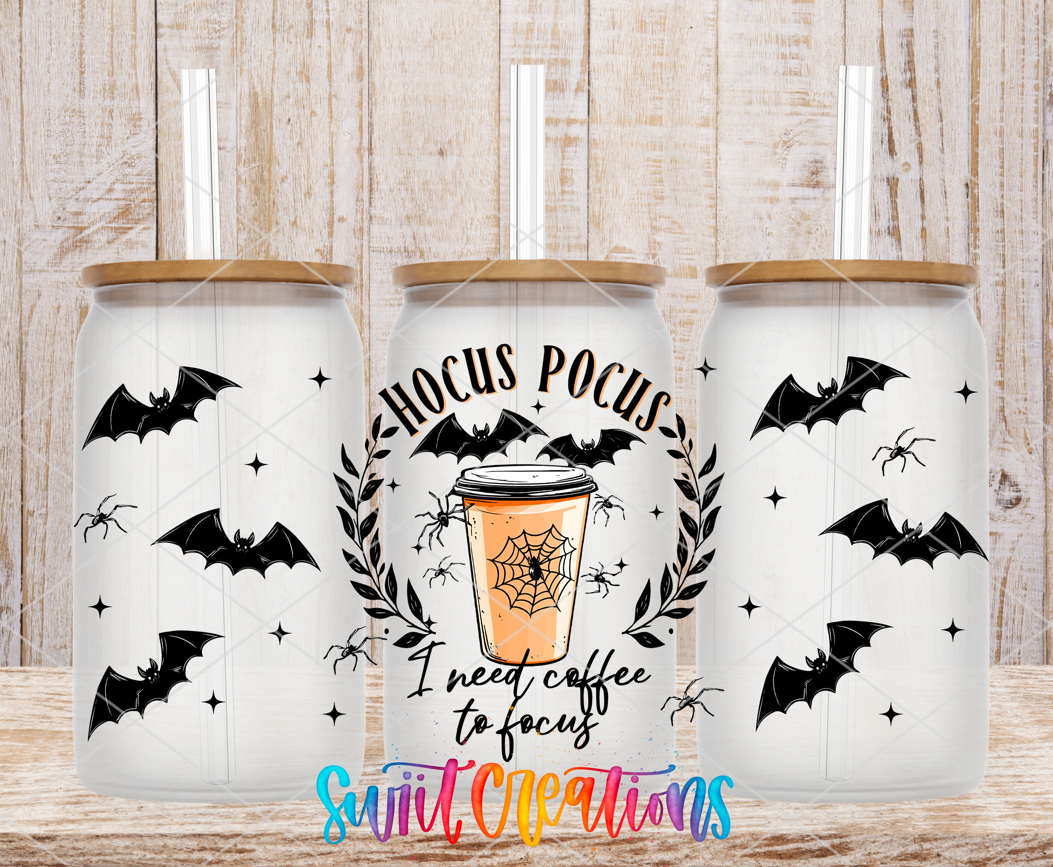 three white tumblers with black bat designs and a spider web motif. The tumblers have a straw and a lid. The central tumbler has a design that says "HOCUS POCUS" and a coffee cup with a spider web. The text "I need coffee to focus" is also present on the tumbler.