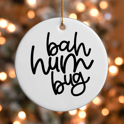 Bah Humbug ornament UV DTF transfer on a round white ornament with a bokeh light background