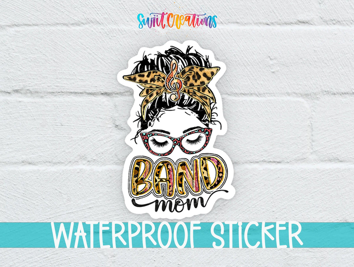 Leopard Messy Bun Band Mom sticker on a white brick background with a waterproof sticker banner