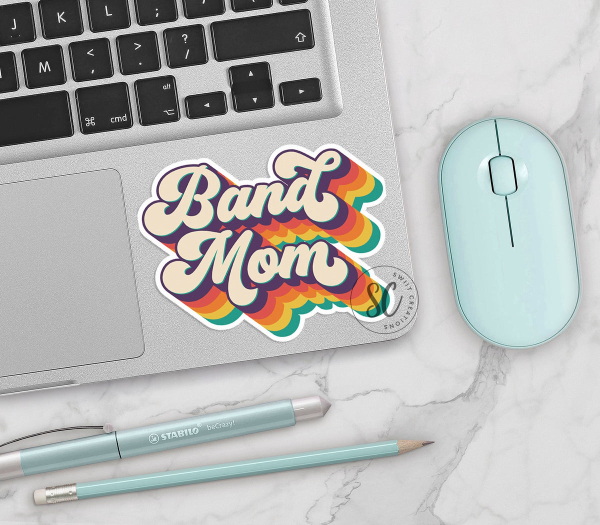 Retro Band Mom vinyl sticker on a silver laptop next to a mint mouse and pens