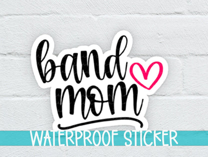 Pink Heart Band Mom sticker on a white brick background with a waterproof sticker banner