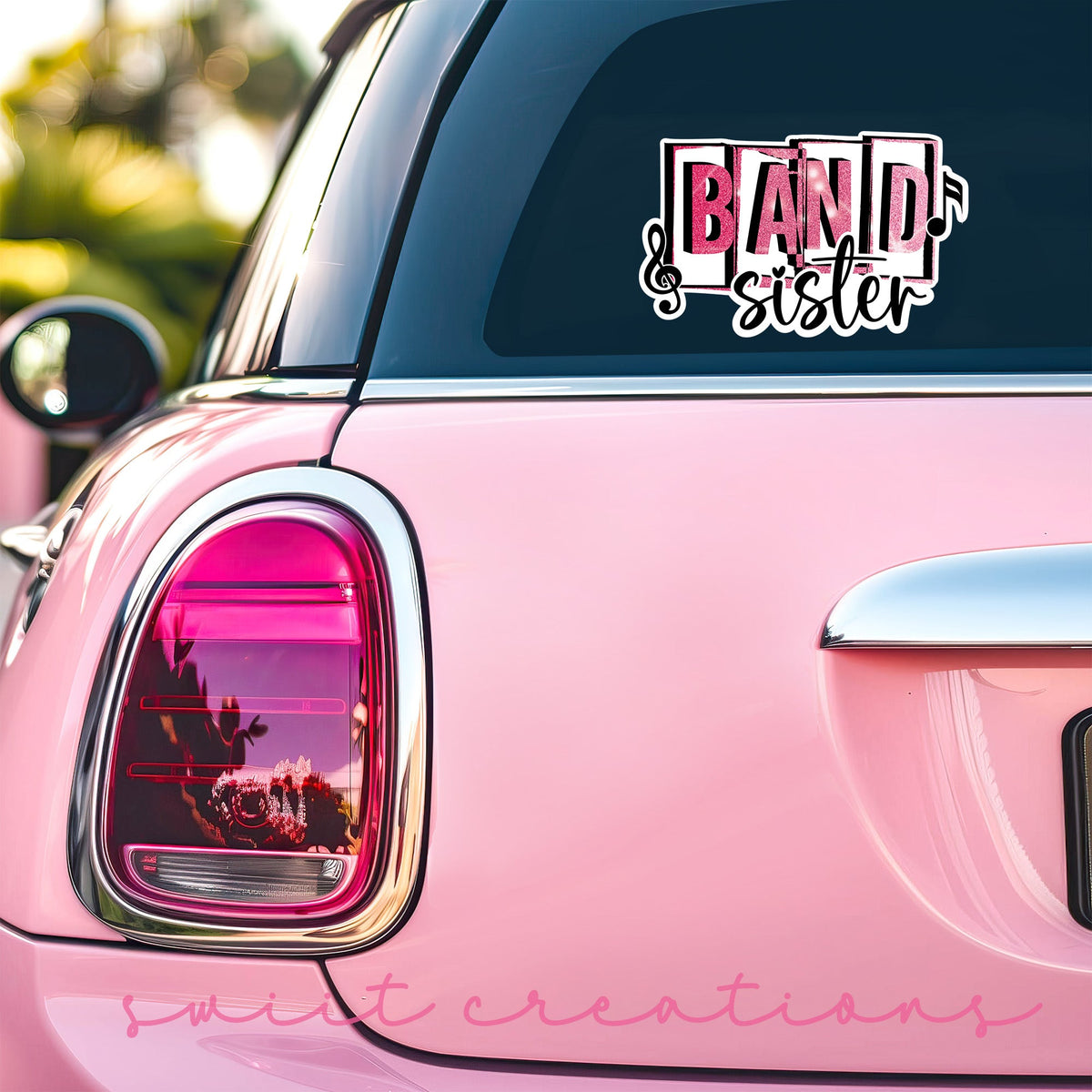 Pink Band Sister sticker on the back window of a pink car