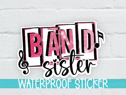 Pink Band Sister sticker on a white brick background with a waterproof sticker banner