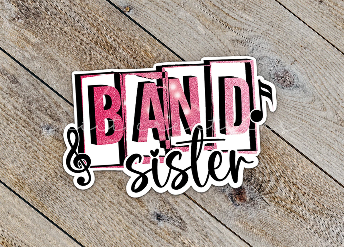 Close-up of the Pink Band Sister sticker on rustic wood
