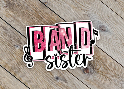 Close-up of the Pink Band Sister sticker on rustic wood
