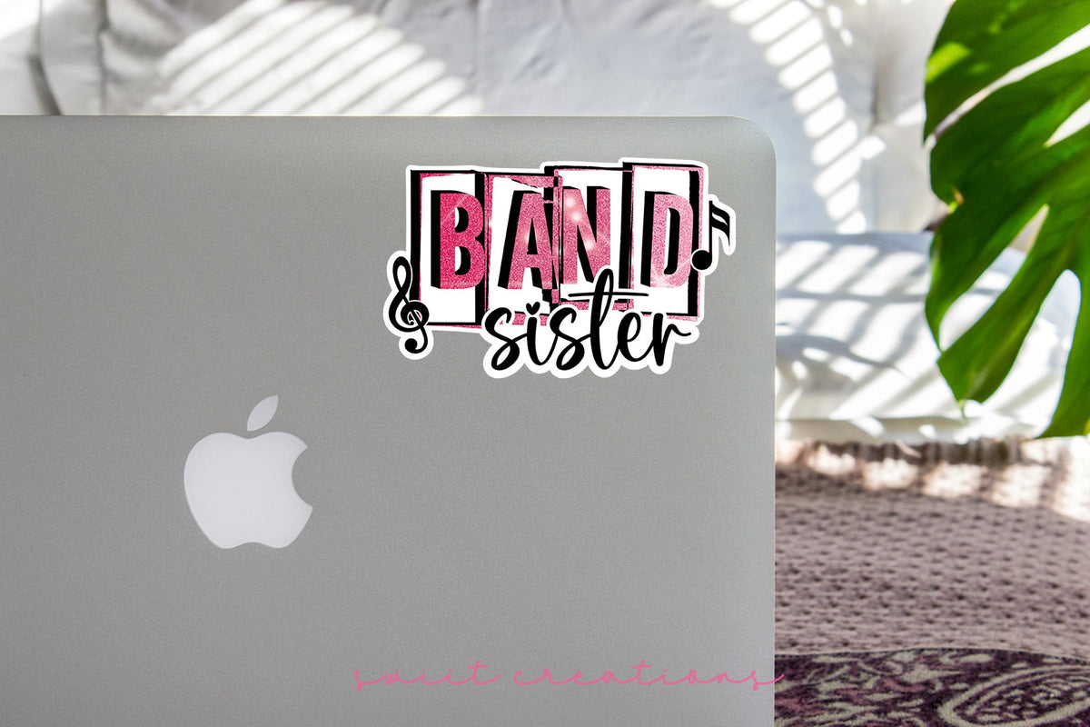 Pink Band Sister sticker on the lid of a silver laptop