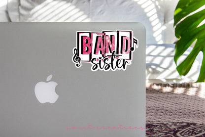 Pink Band Sister sticker on the lid of a silver laptop