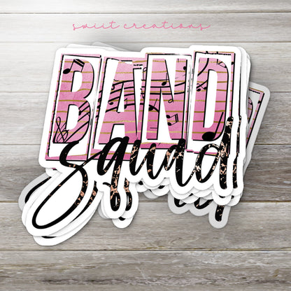 Stack of Band Squad glossy stickers on a gray wood table