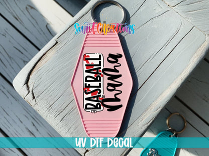 Baseball Mama UV DTF transfer on a pink motel keychain on a wood board