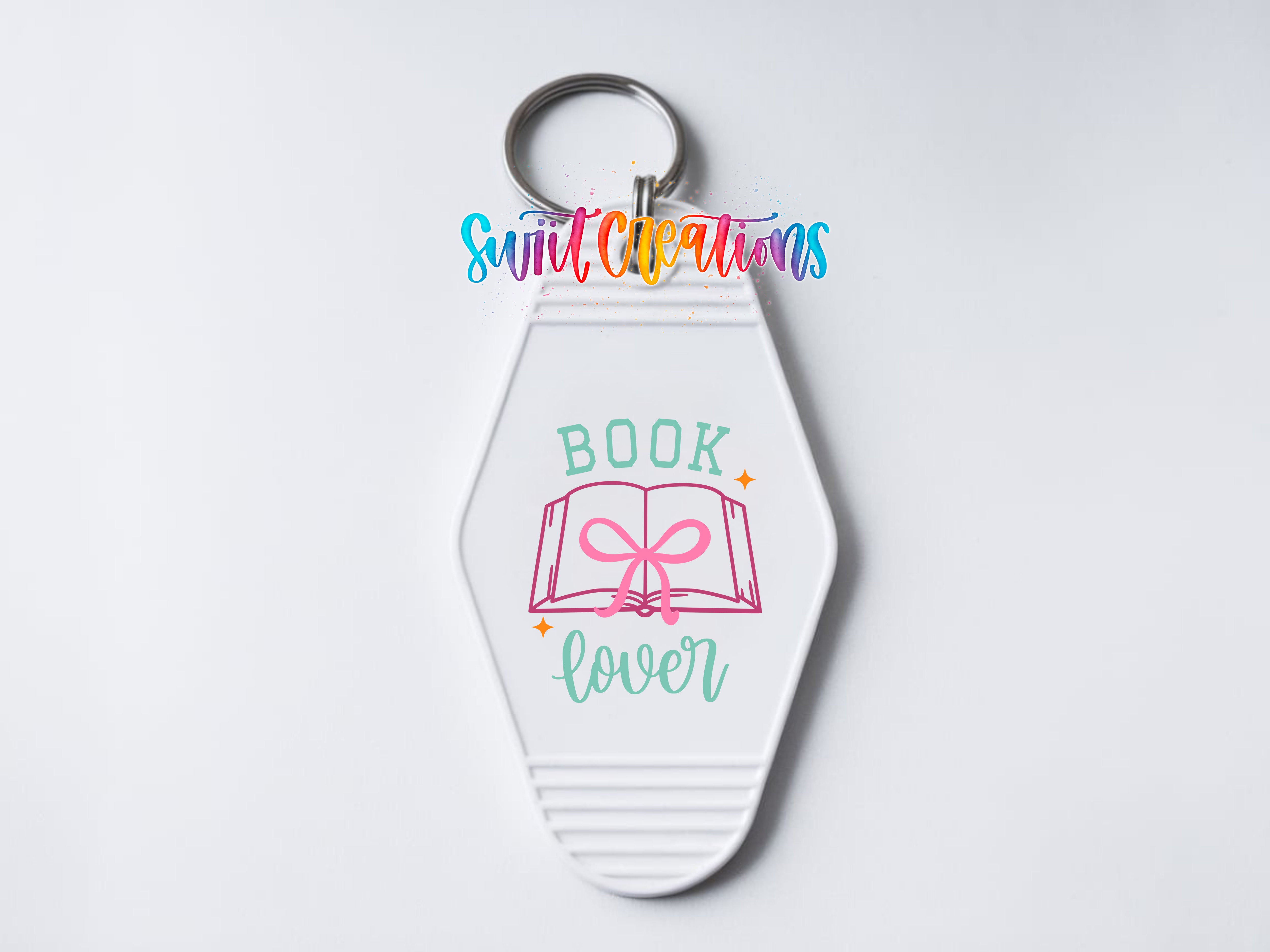 A white keychain with a colorful design and text on it.