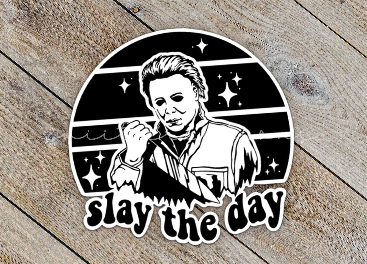 Close-up of the Slay the Day sticker on rustic wood
