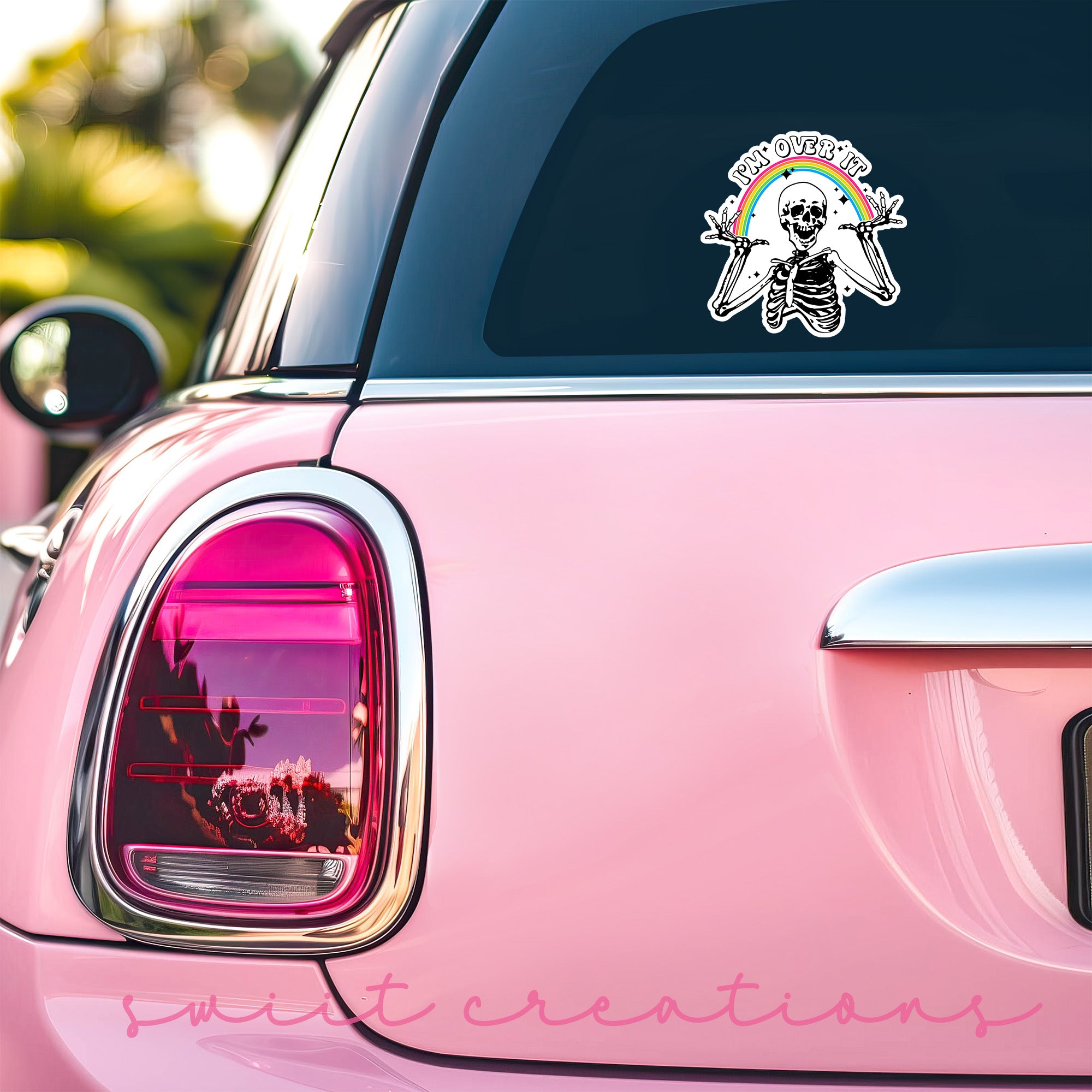 a pink car with a sticker of a skull on it