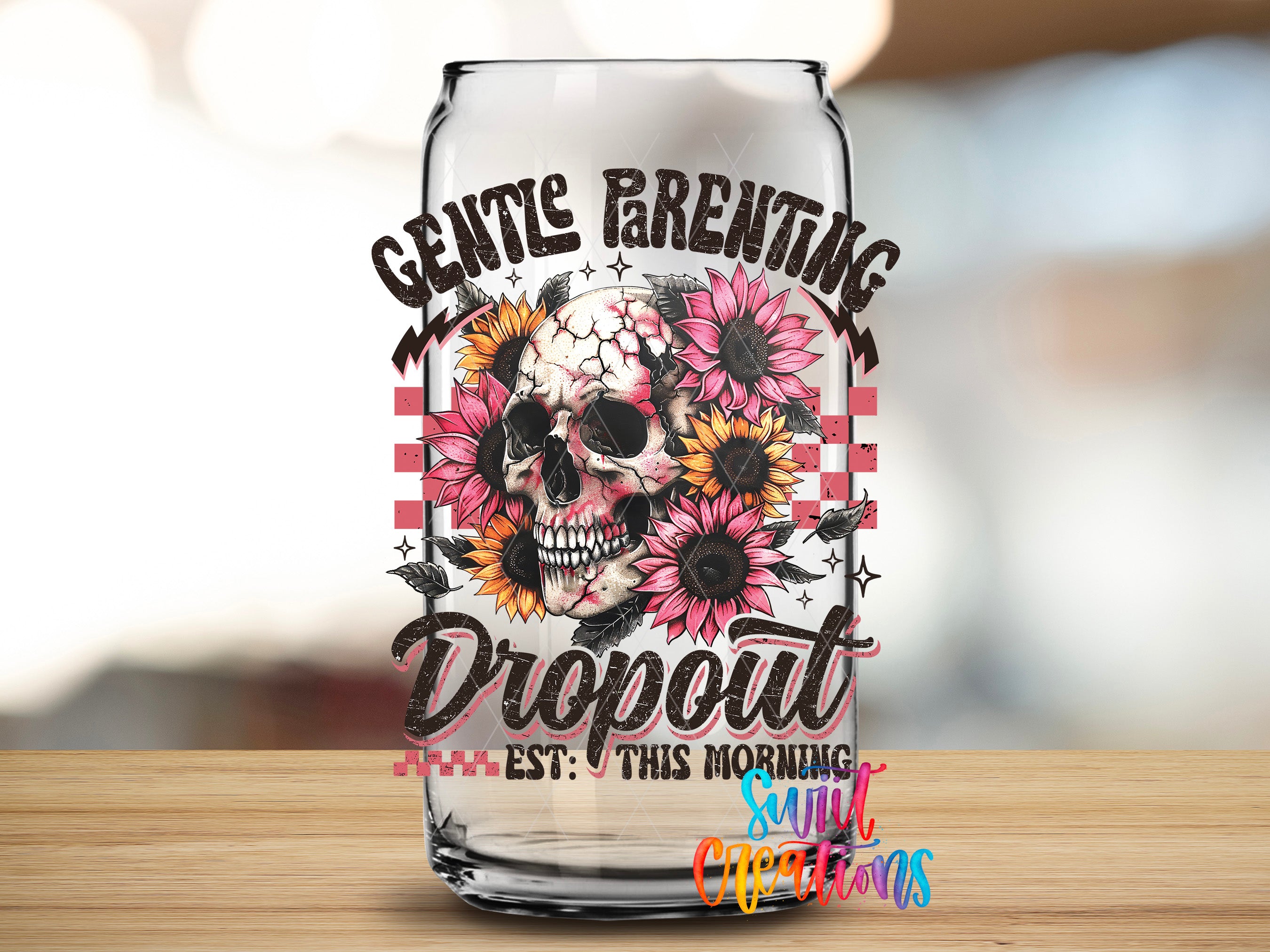 A glass can with a skull and sunflowers design, along with the text "GENTLE PARENTING DROPOUT EST. THIS MORNING SULTIC CREATIONS" printed on it.