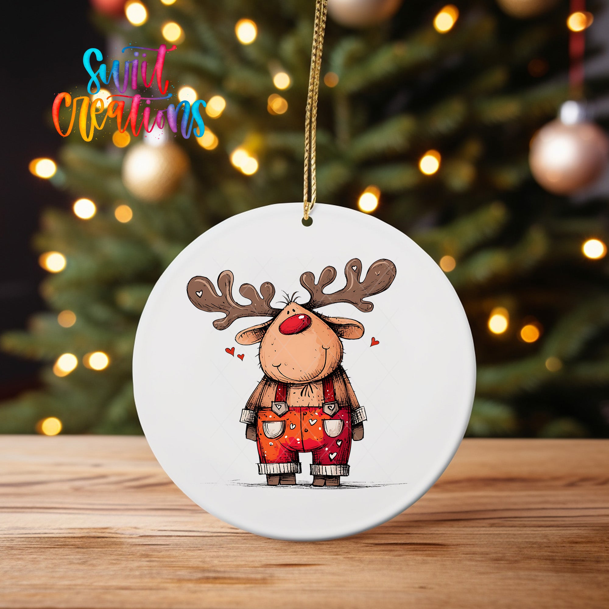 A white ornament featuring a cartoon reindeer with antlers and a red nose, hanging on a string.